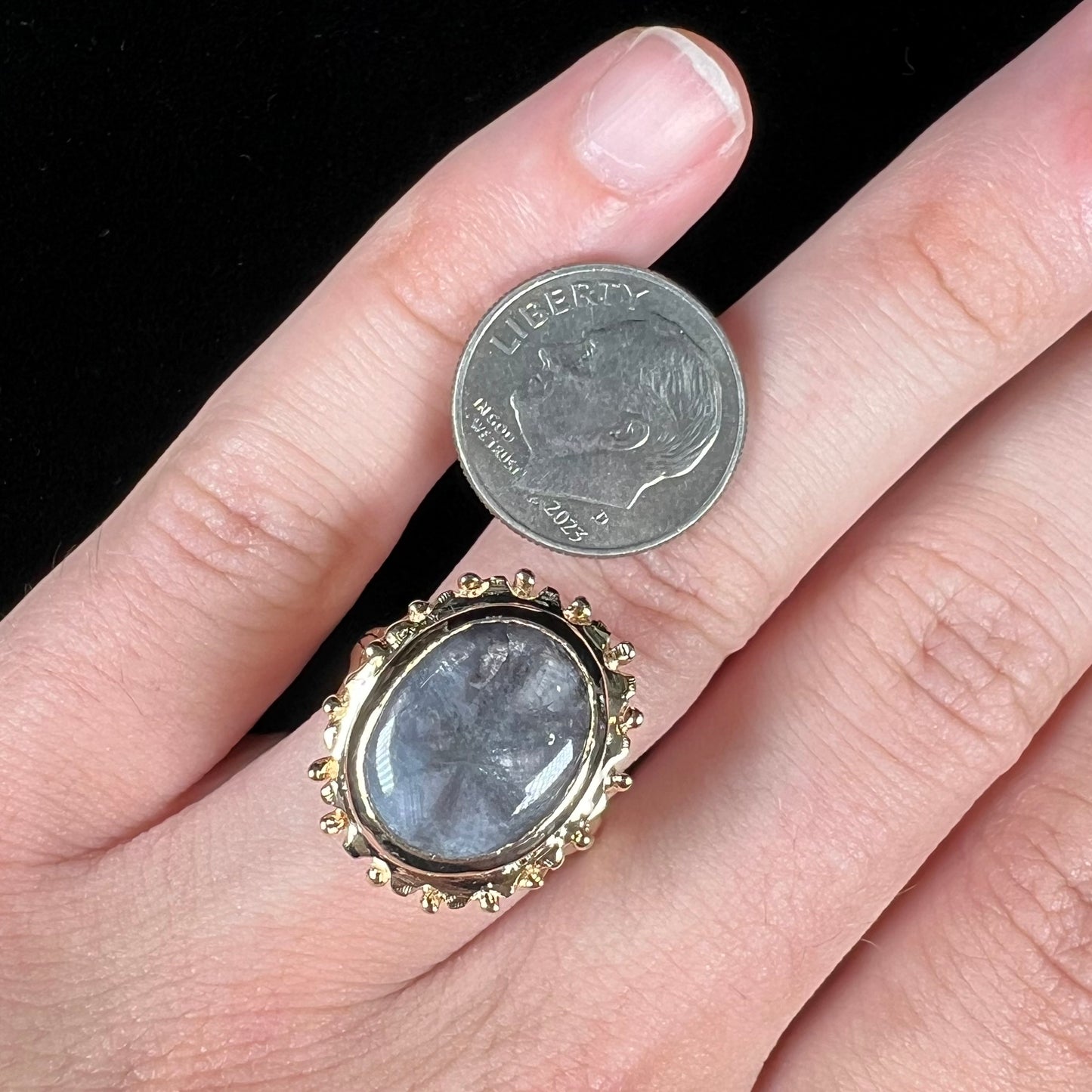 A ladies' yellow gold solitaire ring mounted with a gray trapiche star sapphire.