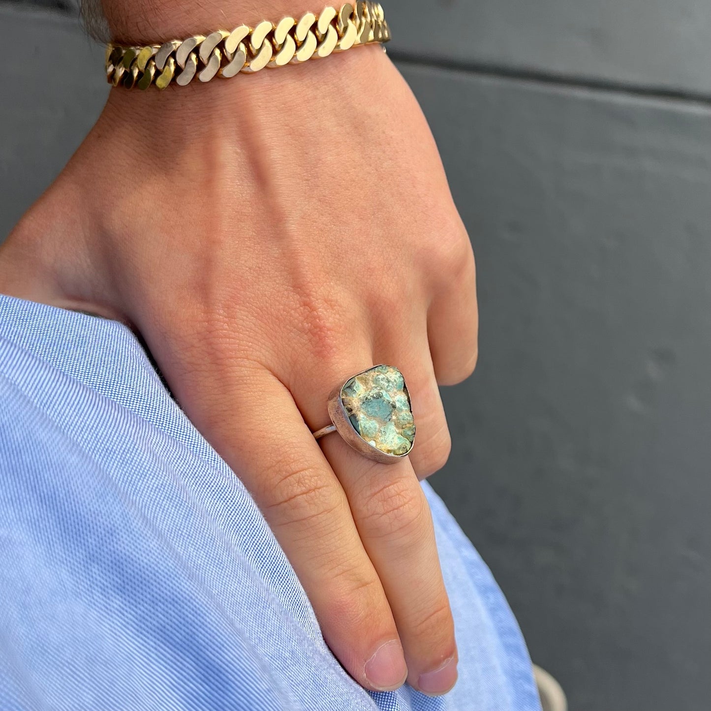 A handmade unisex sterling silver solitaire ring set with a rough, unpolished piece of turquoise stone.