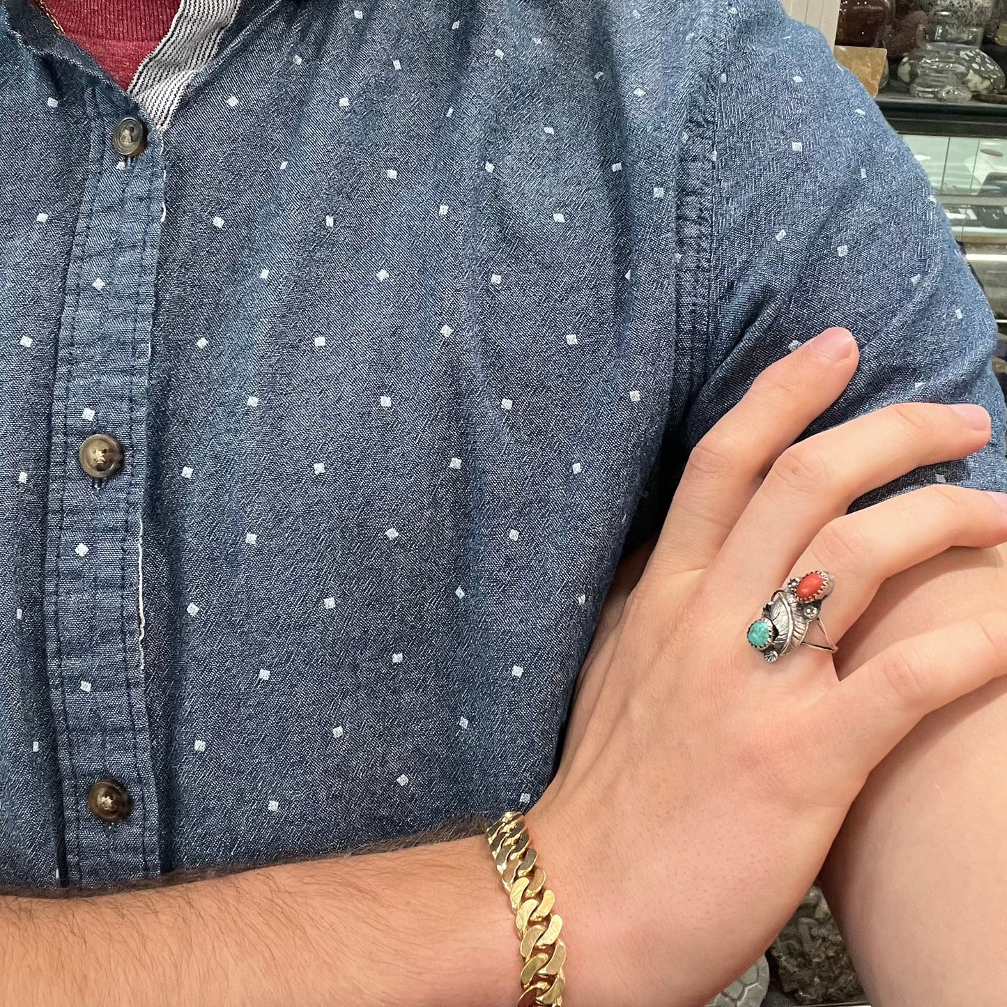 A vintage sterling silver Navajo style ring set with turquoise and coral stones and a feather design.
