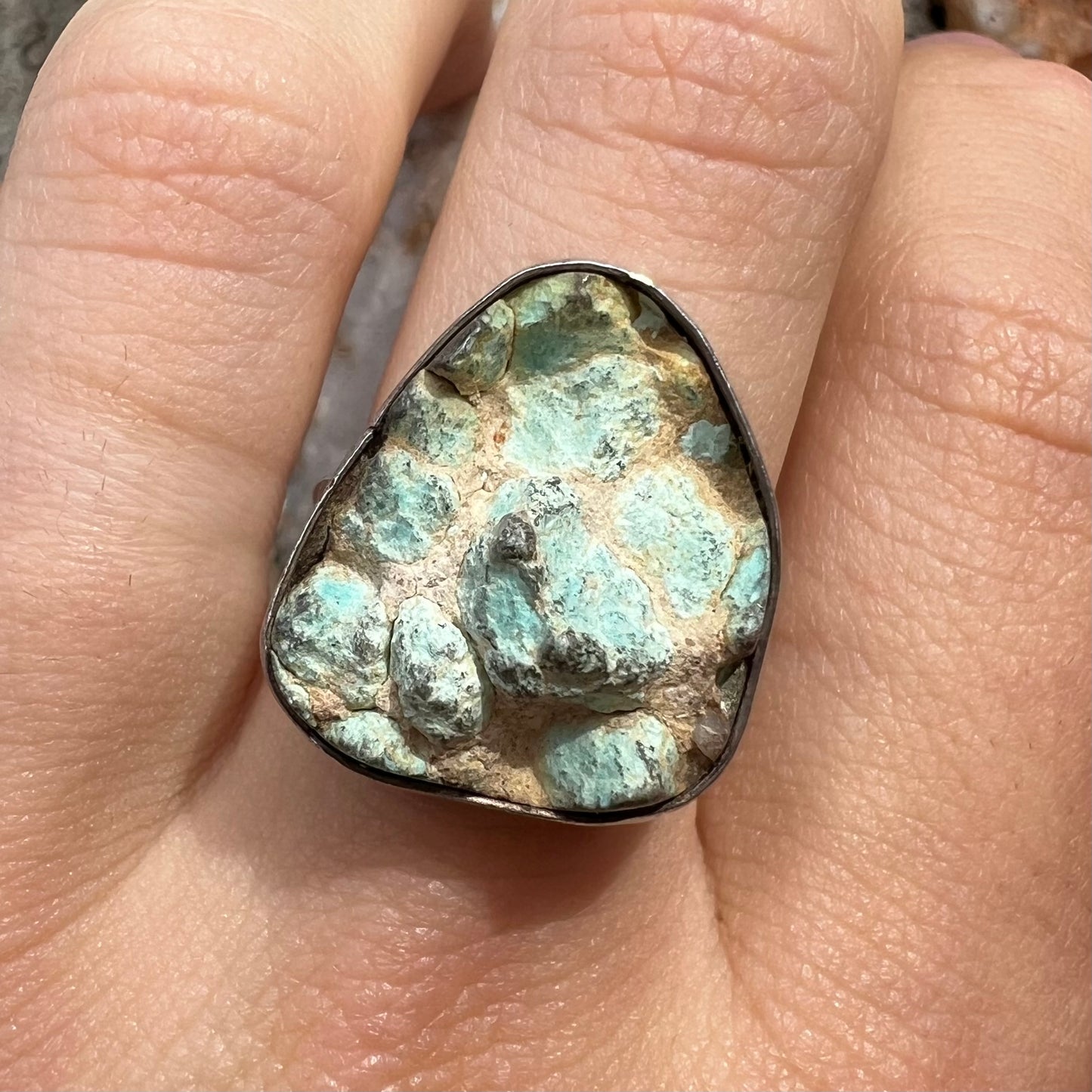 A handmade unisex sterling silver solitaire ring set with a rough, unpolished piece of turquoise stone.