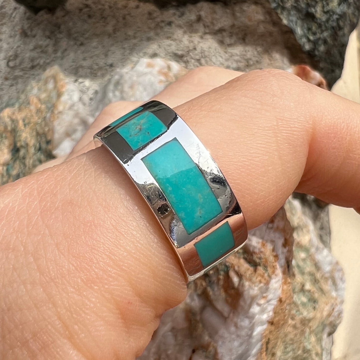 A men's sterling silver wedding band inlaid with natural Sleeping Beauty Turquoise stones that go all the way around.