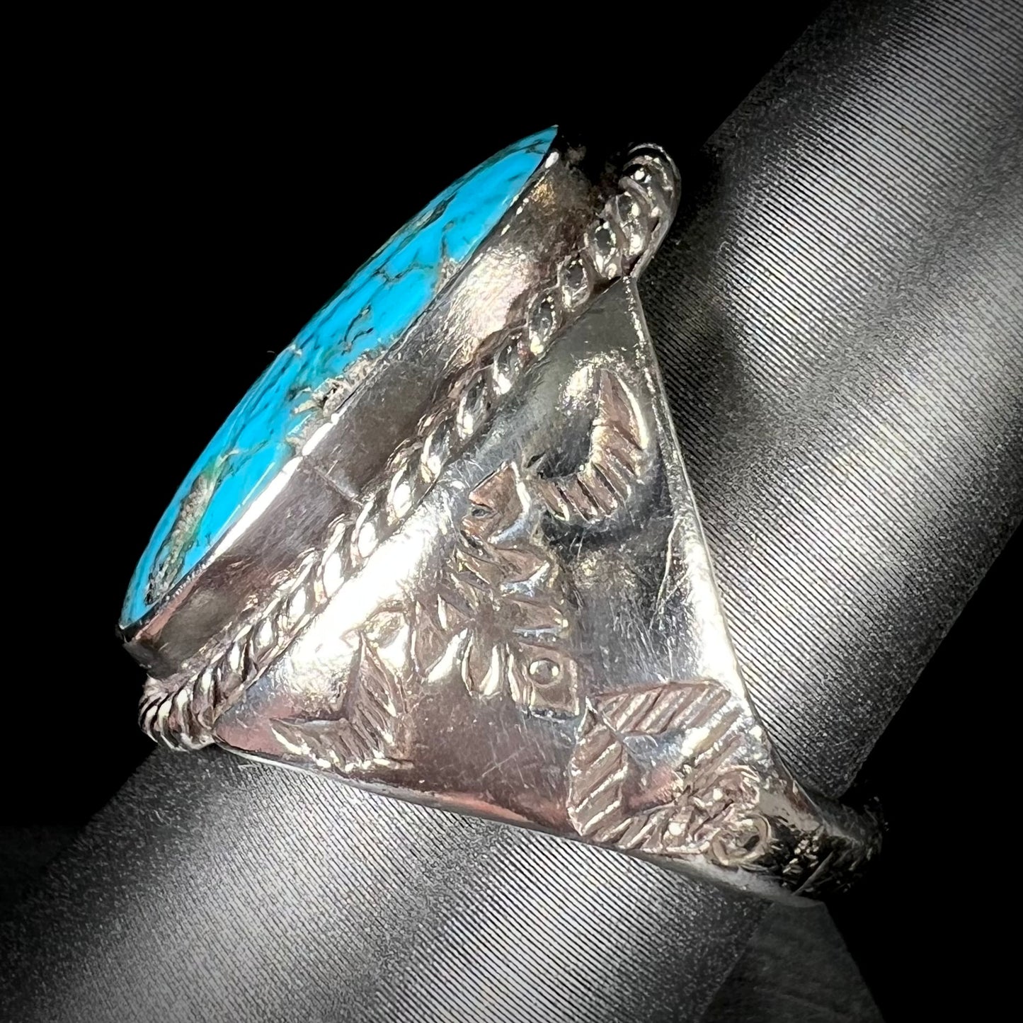 A men's sterling silver Morenci turquoise solitaire ring. The ring has a Southwest Navajo style stamp pattern.