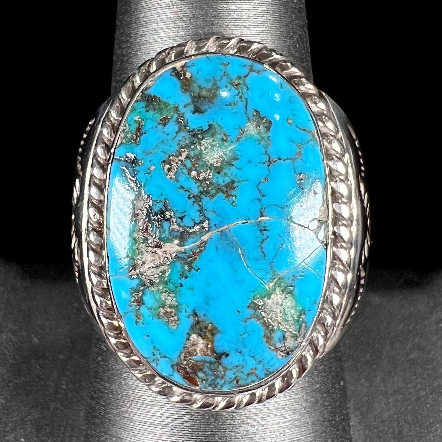 A men's sterling silver Morenci turquoise solitaire ring. The ring has a Southwest Navajo style stamp pattern.