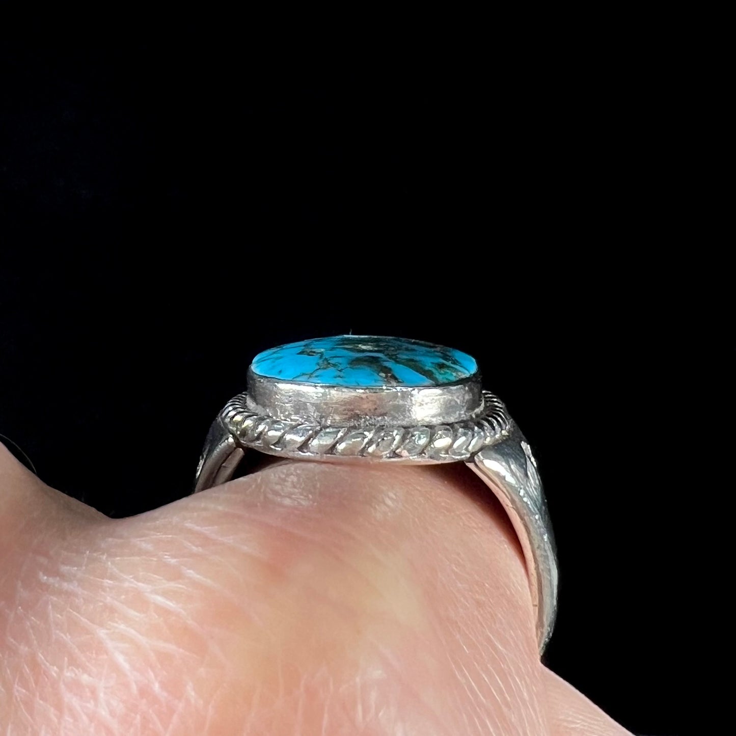 A men's sterling silver Morenci turquoise solitaire ring. The ring has a Southwest Navajo style stamp pattern.