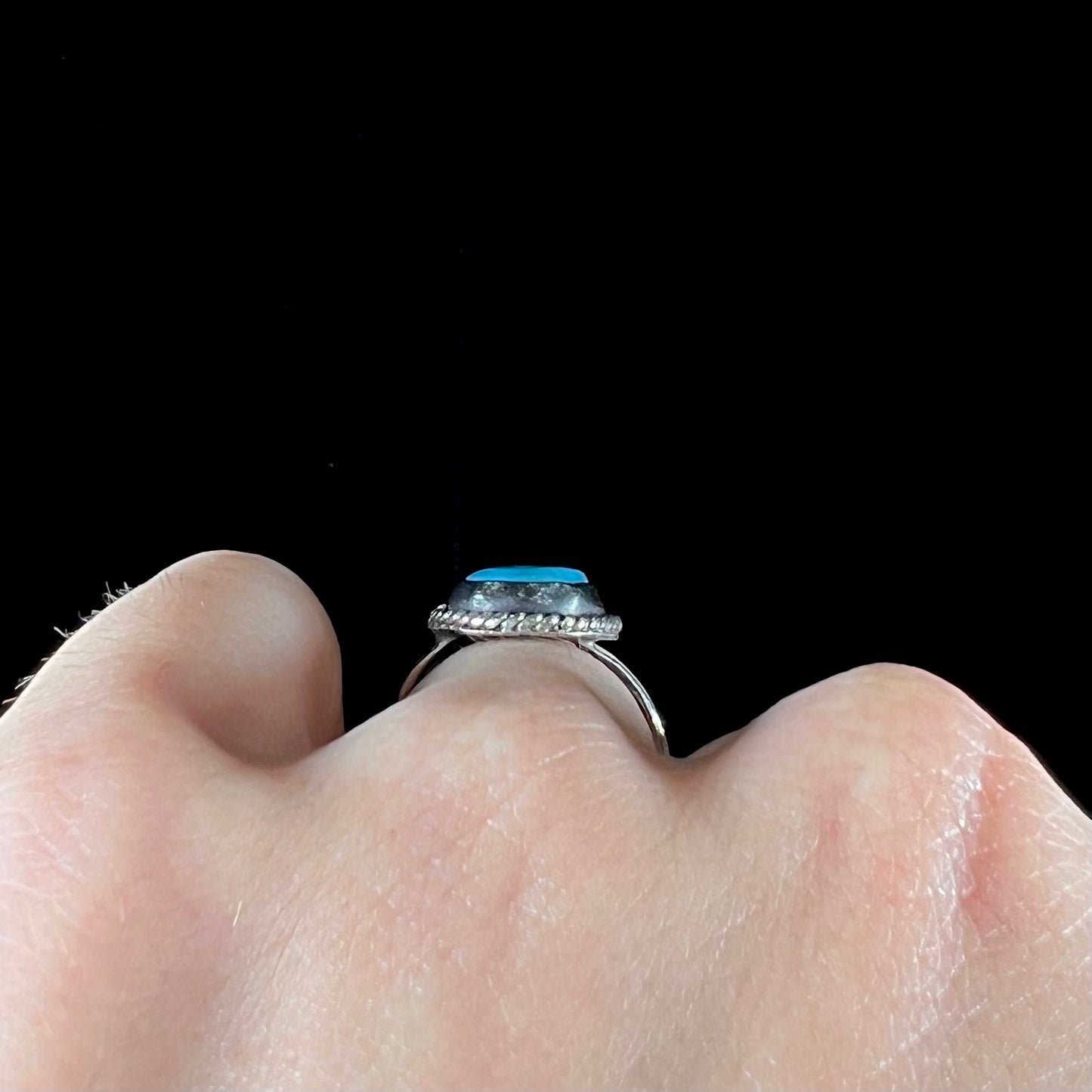 A vintage ladies' Pilot Mountain turquoise ring handmade in sterling silver with a rope accented bezel.