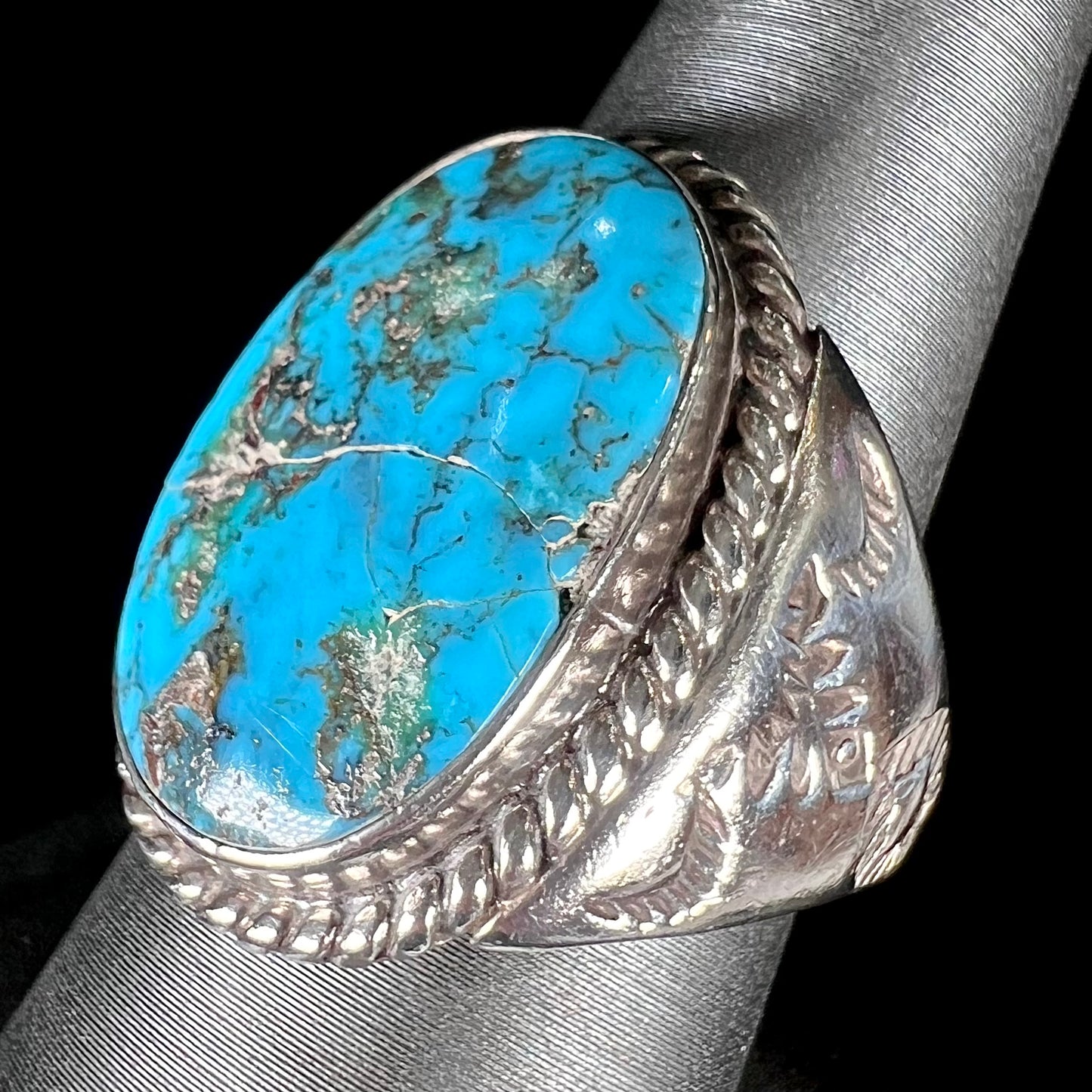 A men's sterling silver Morenci turquoise solitaire ring. The ring has a Southwest Navajo style stamp pattern.