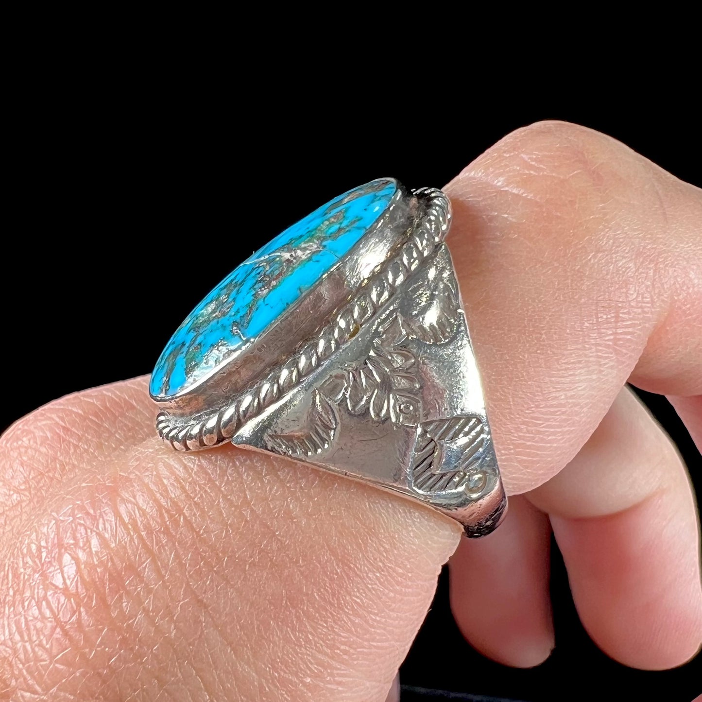A men's sterling silver Morenci turquoise solitaire ring. The ring has a Southwest Navajo style stamp pattern.