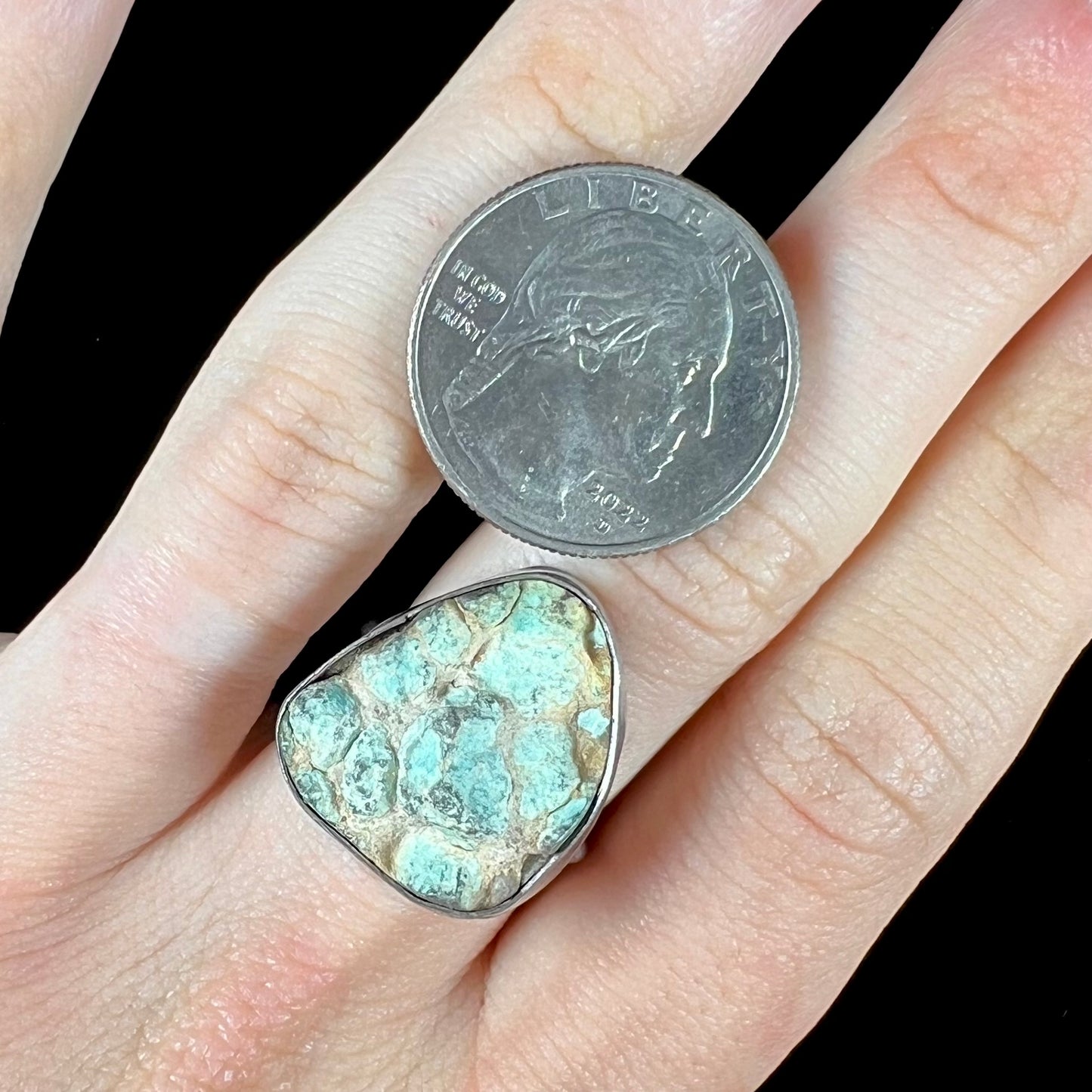 A handmade unisex sterling silver solitaire ring set with a rough, unpolished piece of turquoise stone.