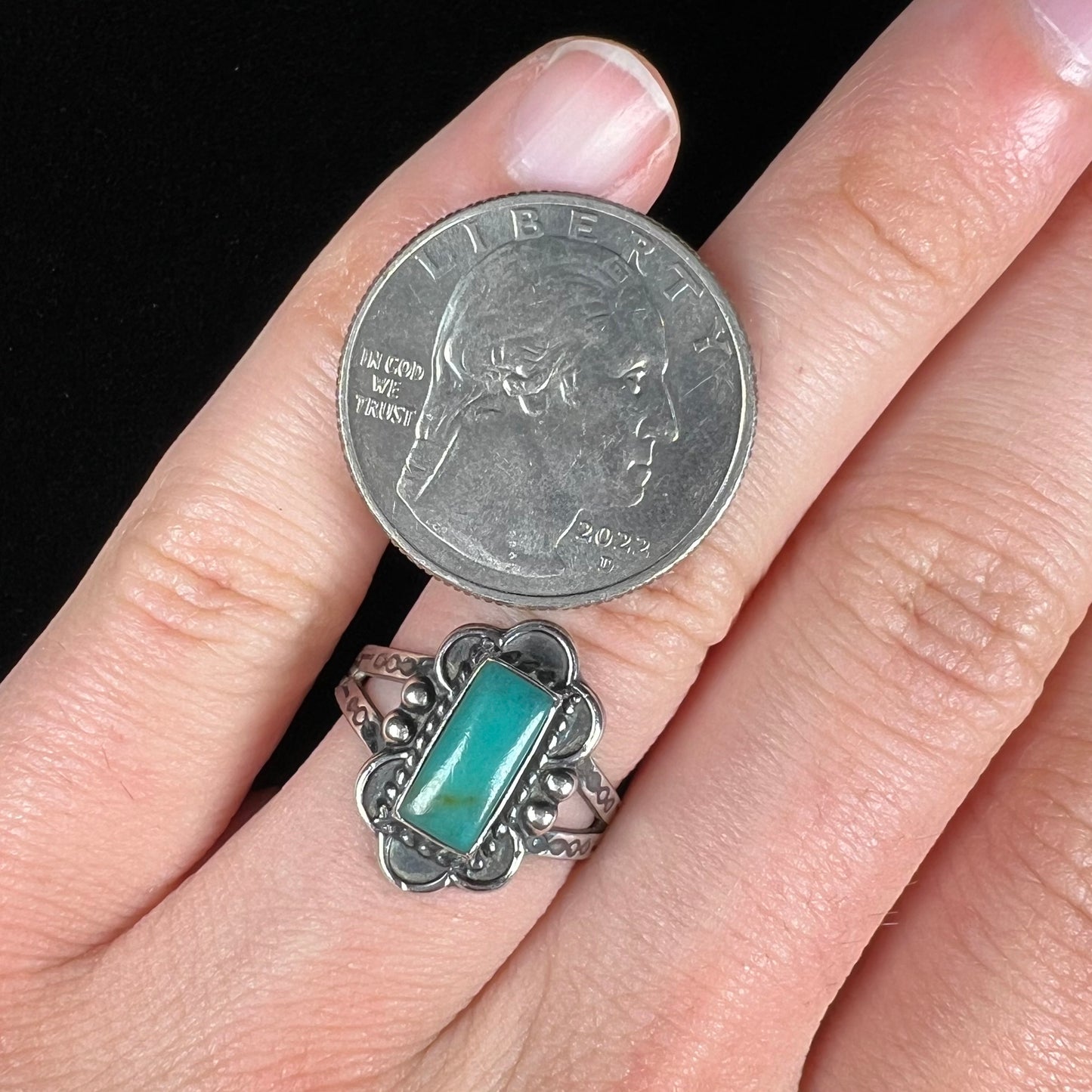 A ladies' silver ring stamped with Southwest style designs and set with a rectangular cabochon cut Royston turquoise stone.