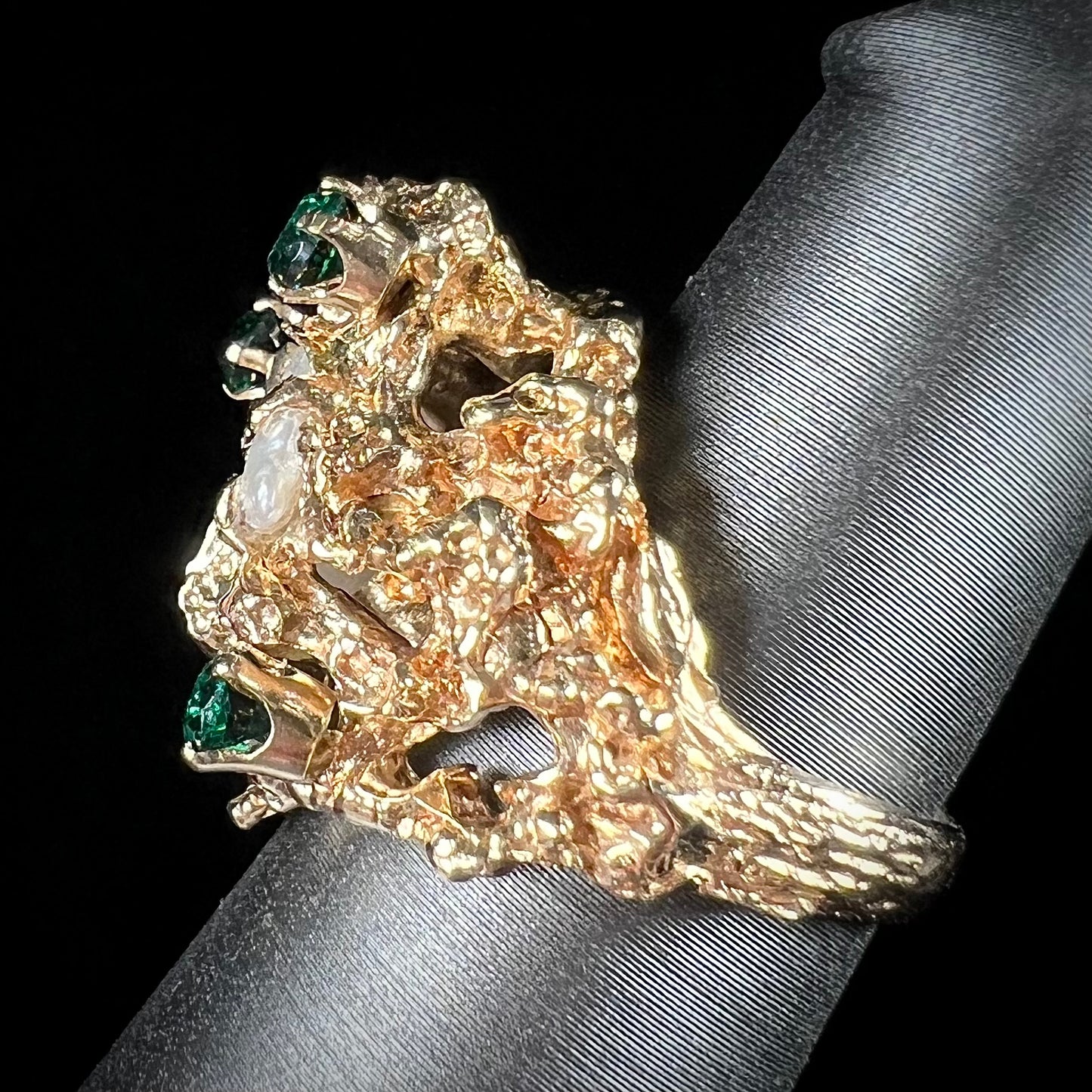 A vintage 1950's gold cluster ring set with freshwater pearls and green imitation emeralds.