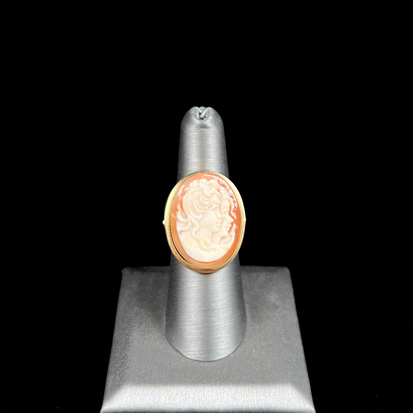 A ladies' vintage cameo solitaire ring in yellow gold. The cameo is carved from shell and depicts the side profile of two womens' faces.