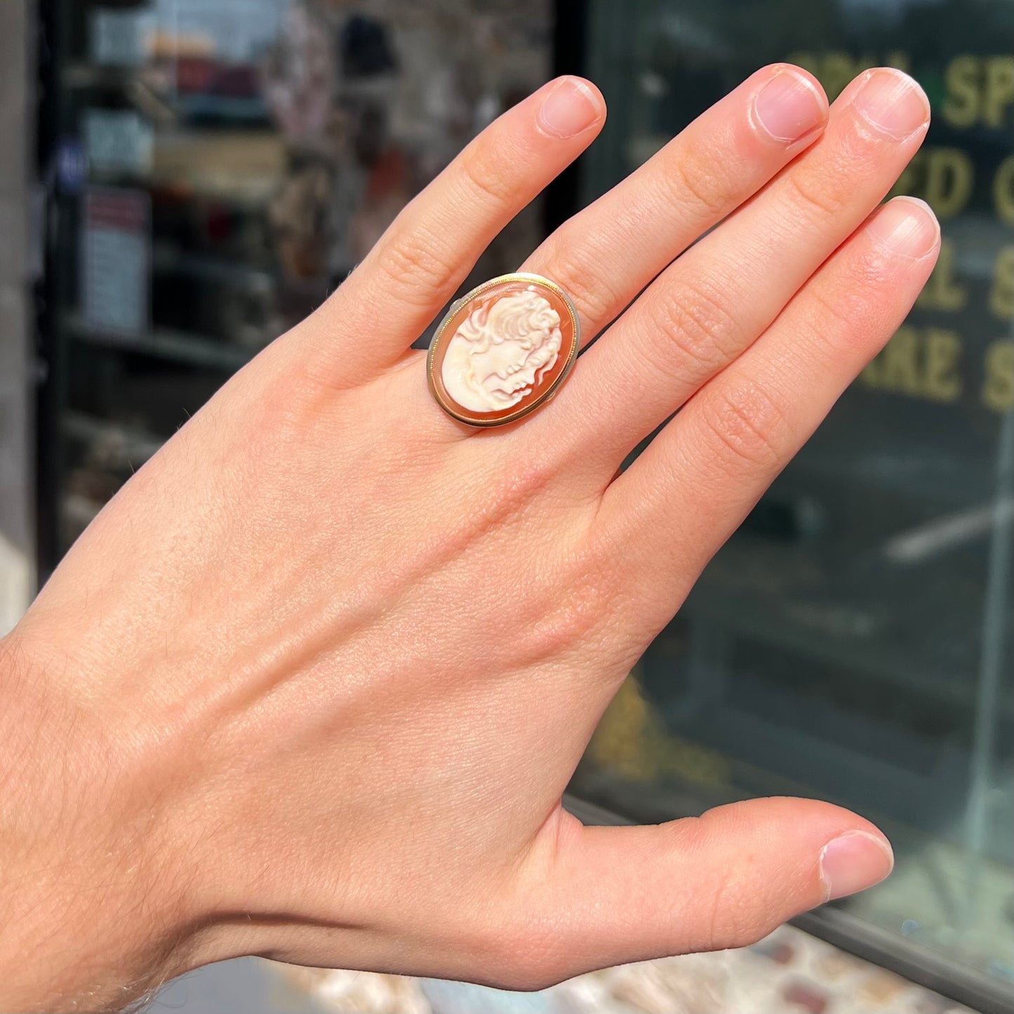 A ladies' vintage cameo solitaire ring in yellow gold. The cameo is carved from shell and depicts the side profile of two womens' faces.