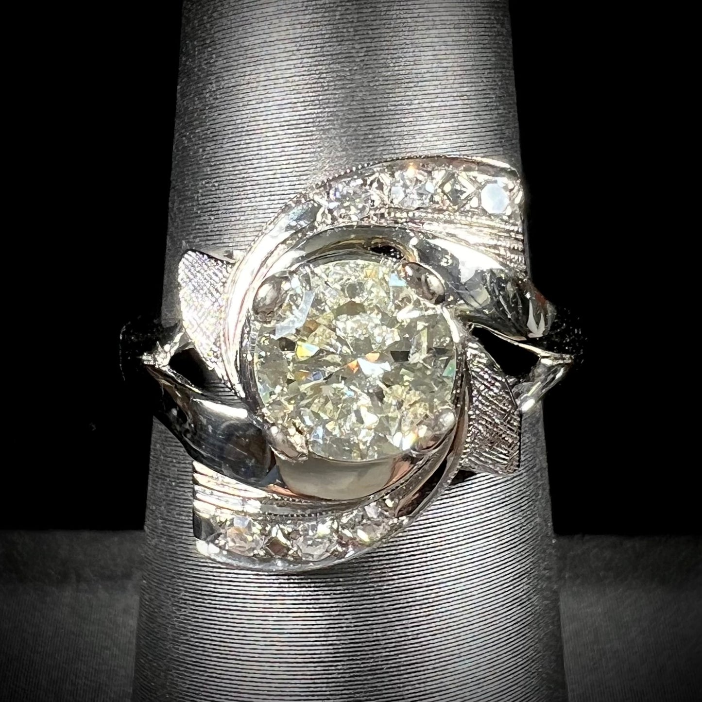 A vintage, Art Nouveau style diamond engagment ring. The ring is white gold with a yellowish, M colored, 1.24 carat diamond.