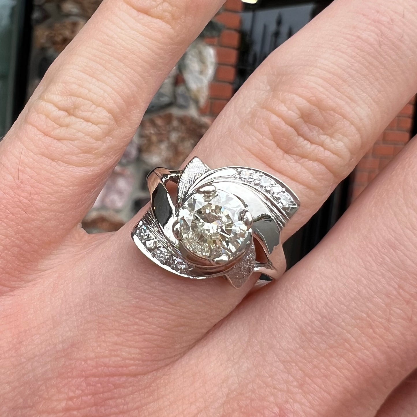 A vintage, Art Nouveau style diamond engagment ring. The ring is white gold with a yellowish, M colored, 1.24 carat diamond.