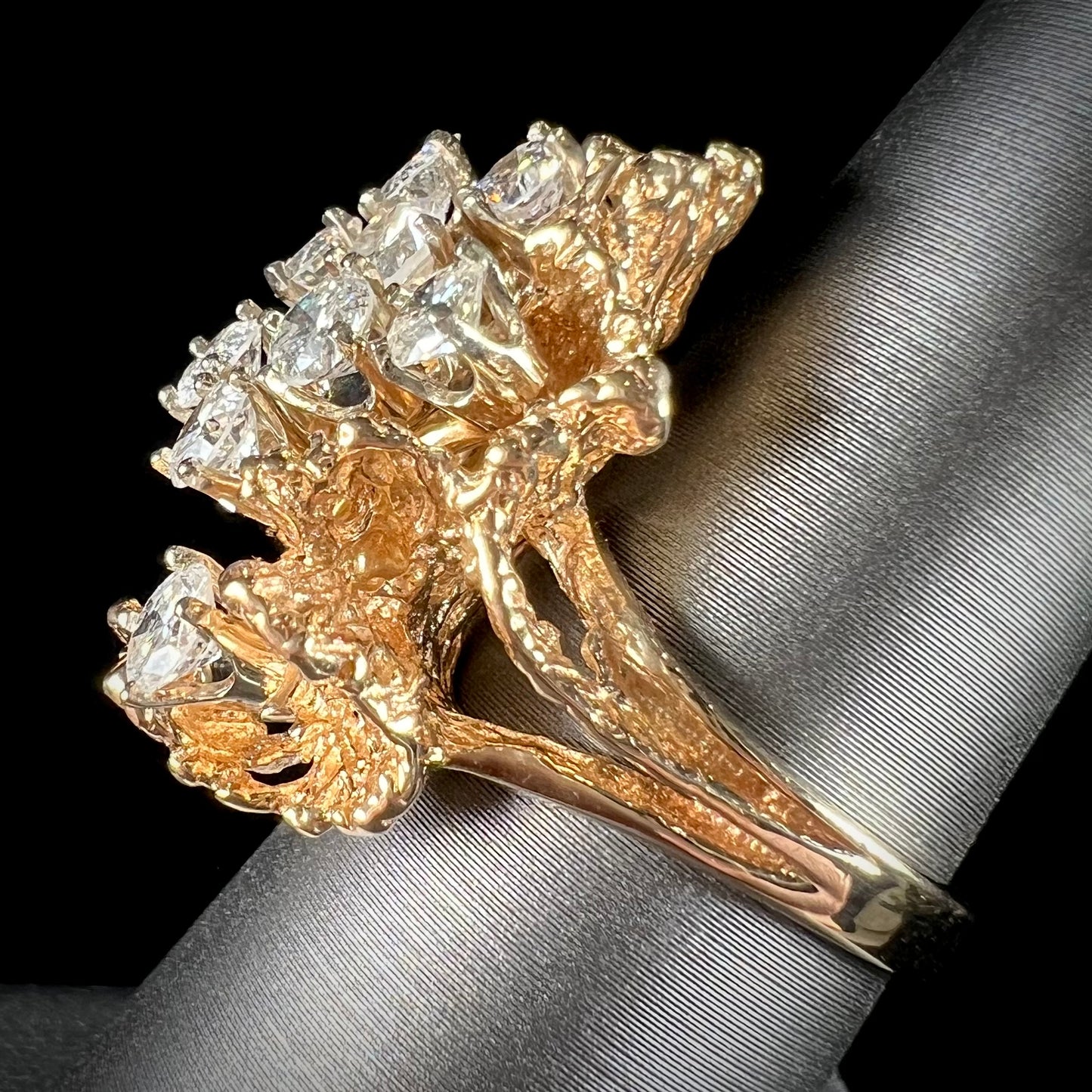 A ladies' 1950's style yellow gold and diamond cluster ring. The ring is shaped like a leaf with 10 round diamonds set in it.