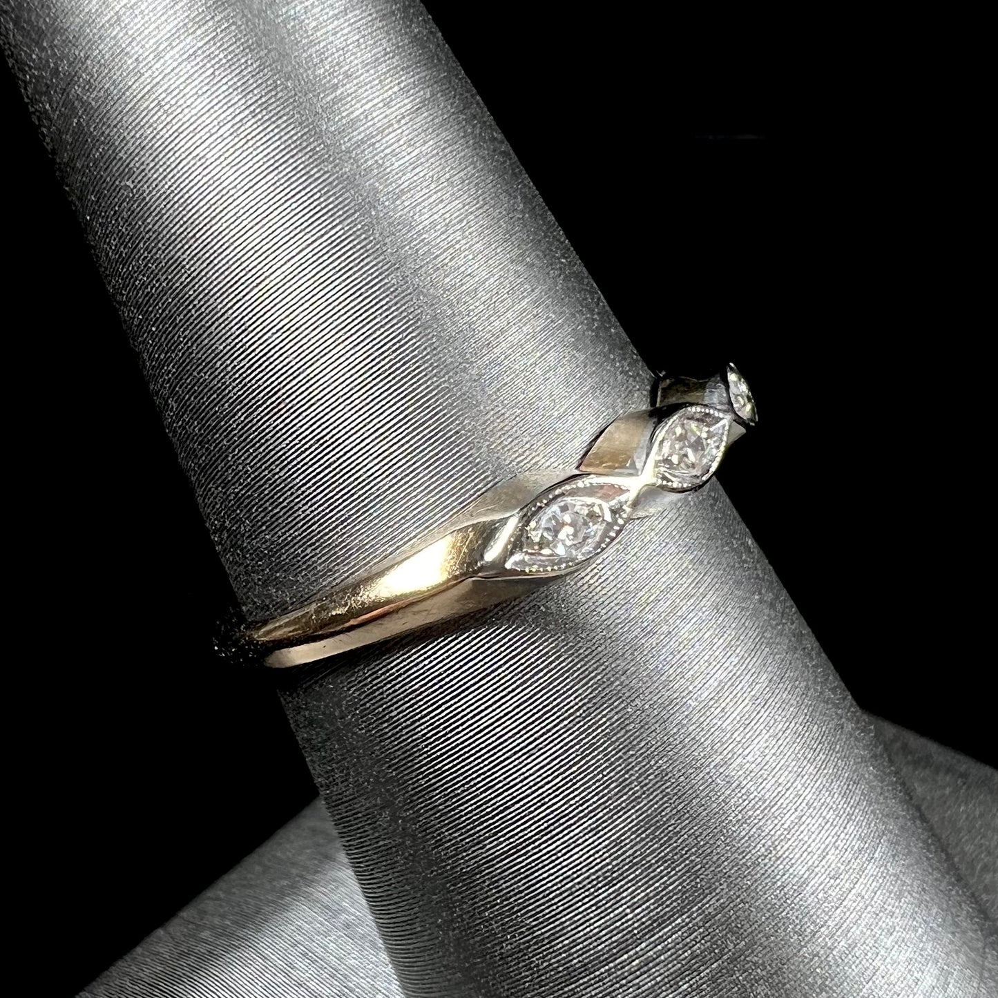 A vintage, yellow gold ladies' wedding band set with three single cut diamonds in marquise shaped designs.