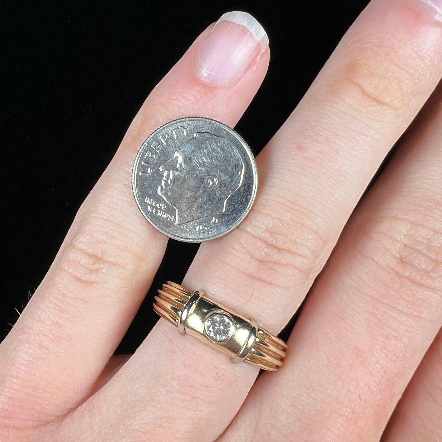 A unisex, vintage style two tone yellow and white gold wedding ring bezel set with a round diamond.