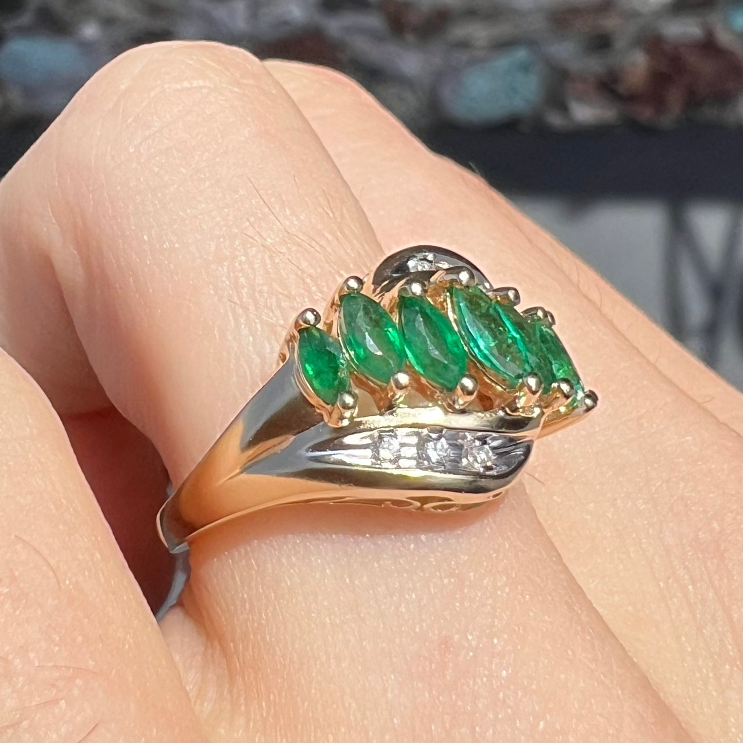 A vintage, 1970's style yellow gold ring set with marquise cut emeralds and round brilliant cut diamonds.
