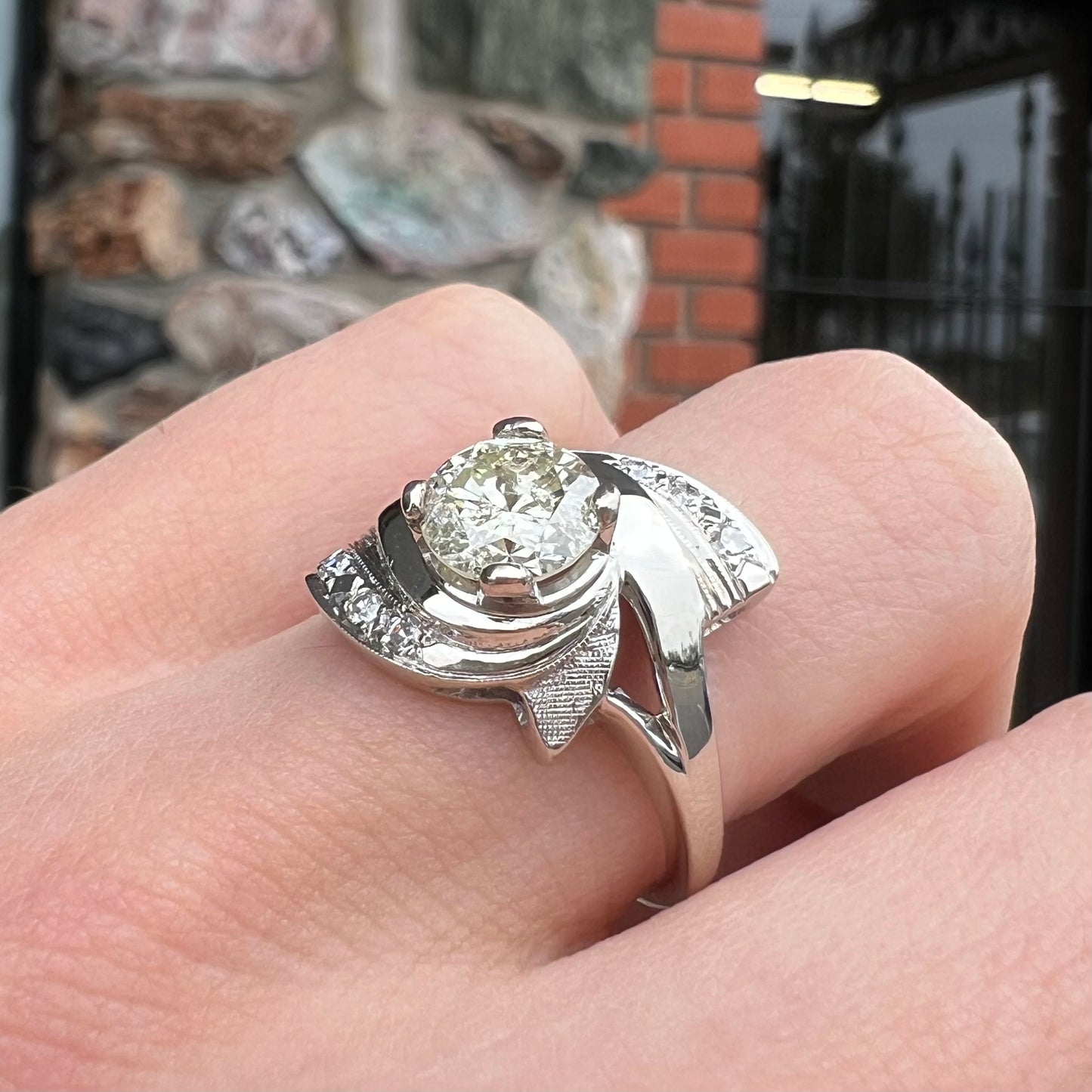 A vintage, Art Nouveau style diamond engagment ring. The ring is white gold with a yellowish, M colored, 1.24 carat diamond.