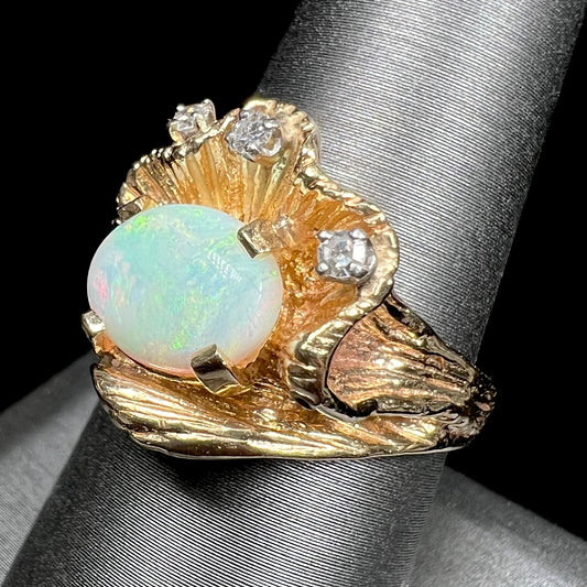 A 1960s style white opal and diamond ring.  The ring has an organic, ruffled gold design.