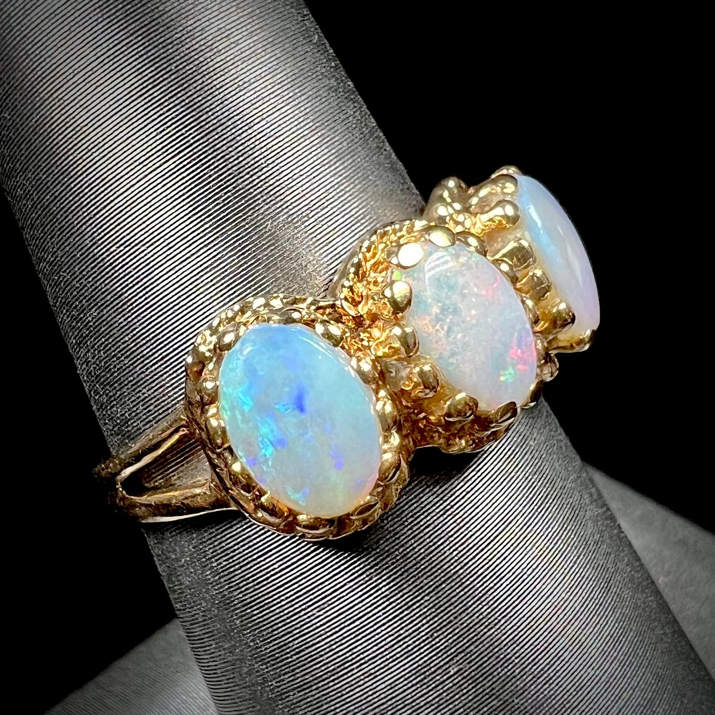 A vintage ladies' three stone gold ring set with natural white crystal opals.