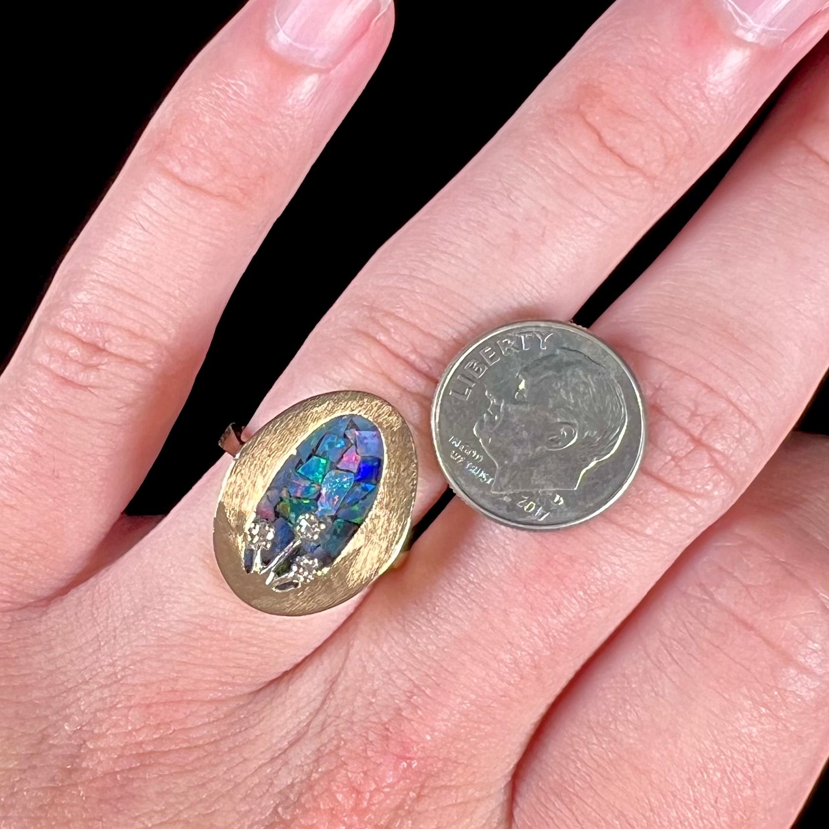 A vintage mosaic opal ring set with diamond accents in 10 karat yellow and white gold.