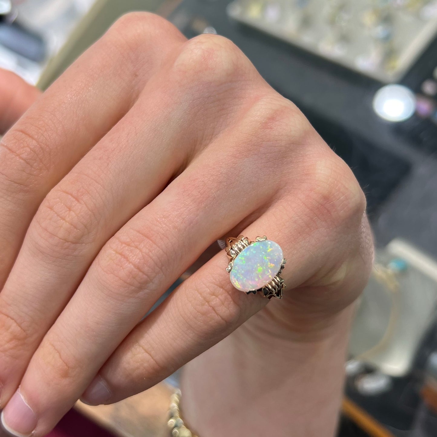 A ladies' Art Deco style natural opal solitaire ring in yellow gold. The opal is oval cut.