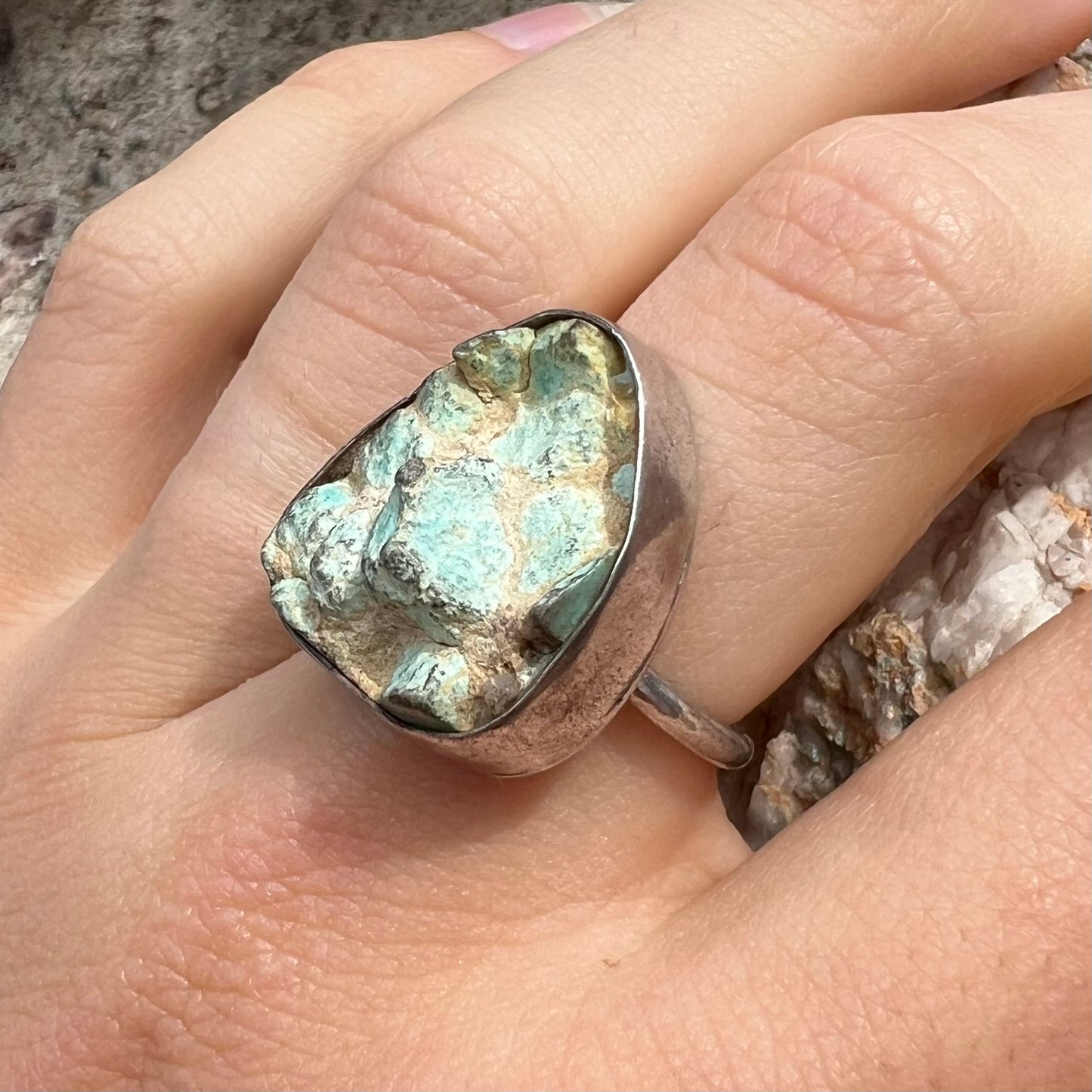 A handmade unisex sterling silver solitaire ring set with a rough, unpolished piece of turquoise stone.