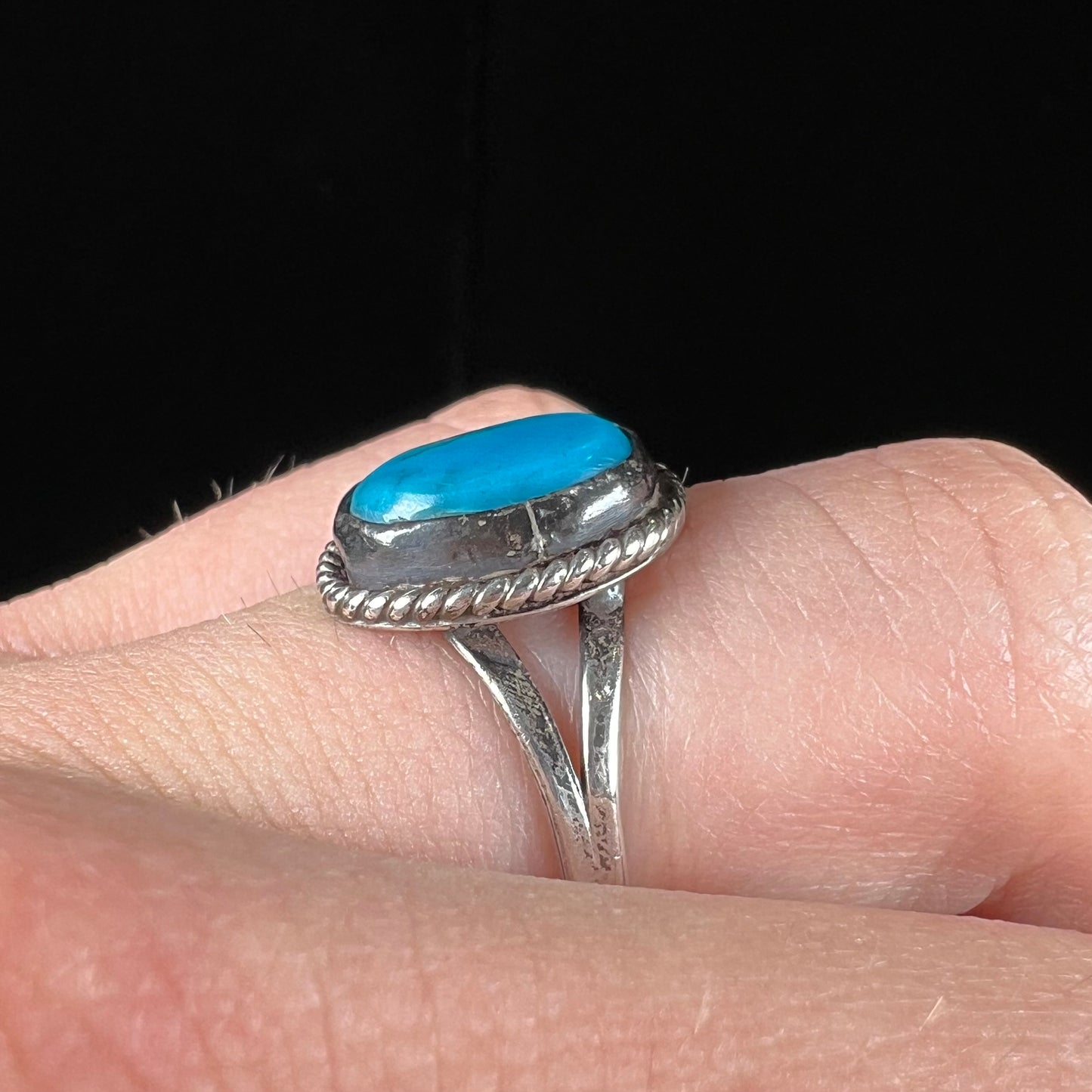 A vintage ladies' Pilot Mountain turquoise ring handmade in sterling silver with a rope accented bezel.