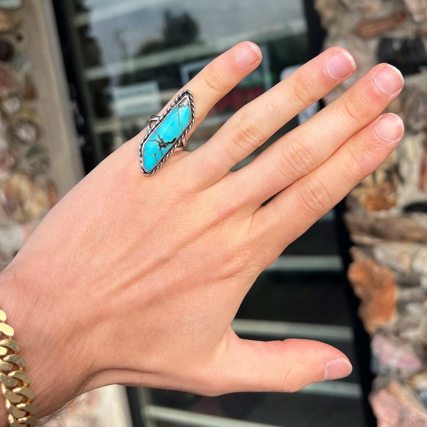 A vintage, Southwest style sterling silver ring set with a natural turquoise stone. The stone is blue with a black matrix.