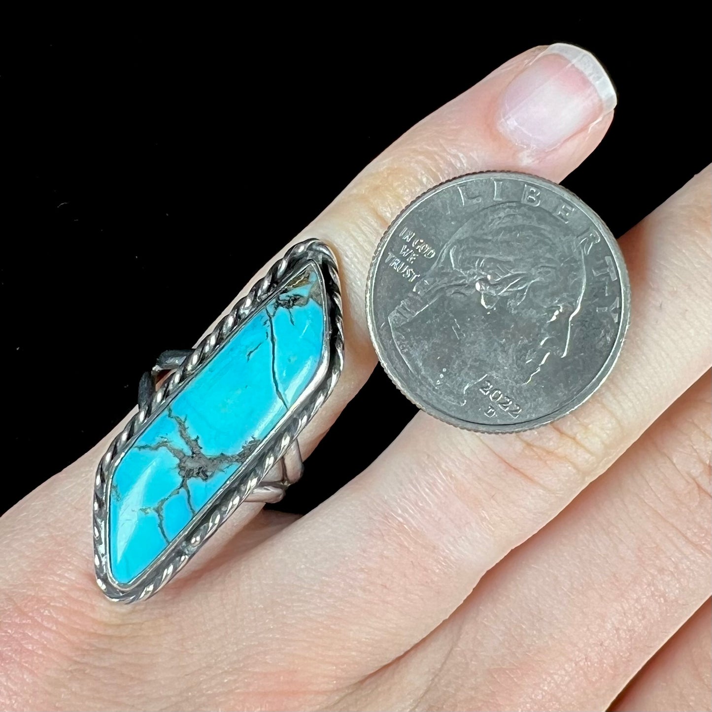 A vintage, Southwest style sterling silver ring set with a natural turquoise stone. The stone is blue with a black matrix.