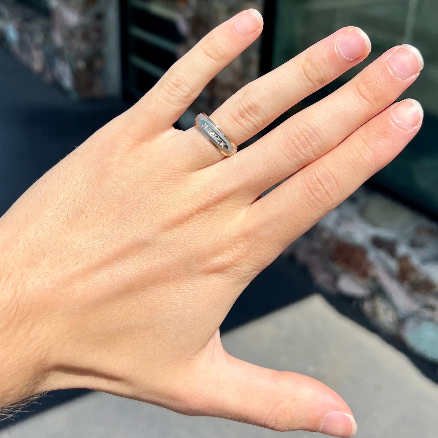 A unisex, two-tone white and yellow gold diamond wedding band. The white gold is textured.
