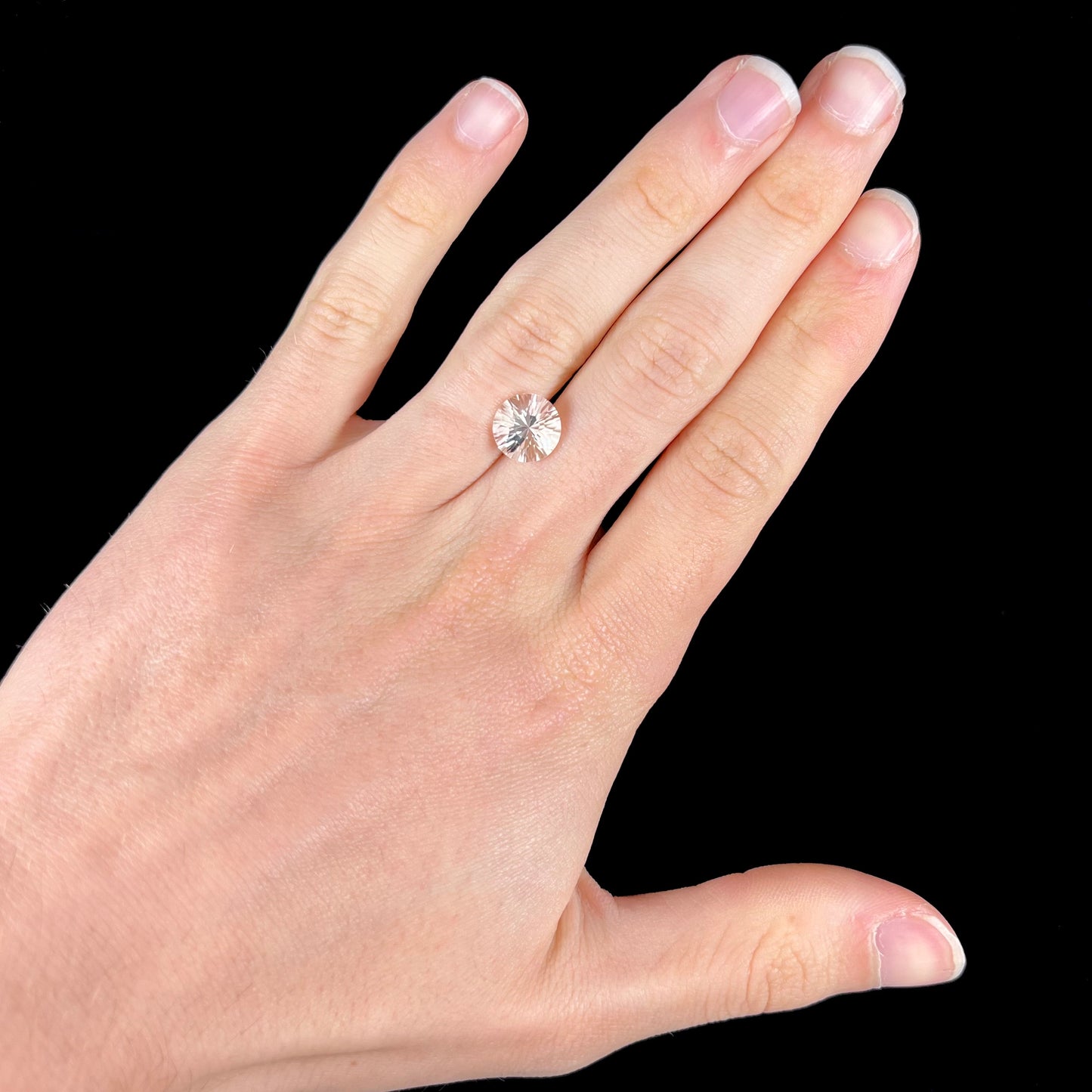 A round brilliant cut petalite gemstone. The stone is colorless.