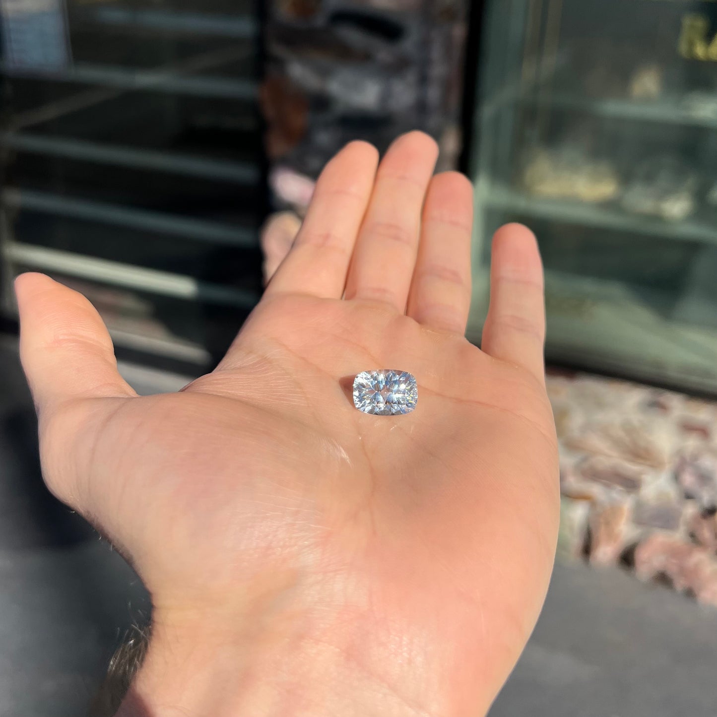 A loose, modified laser cushion cut white topaz gemstone.