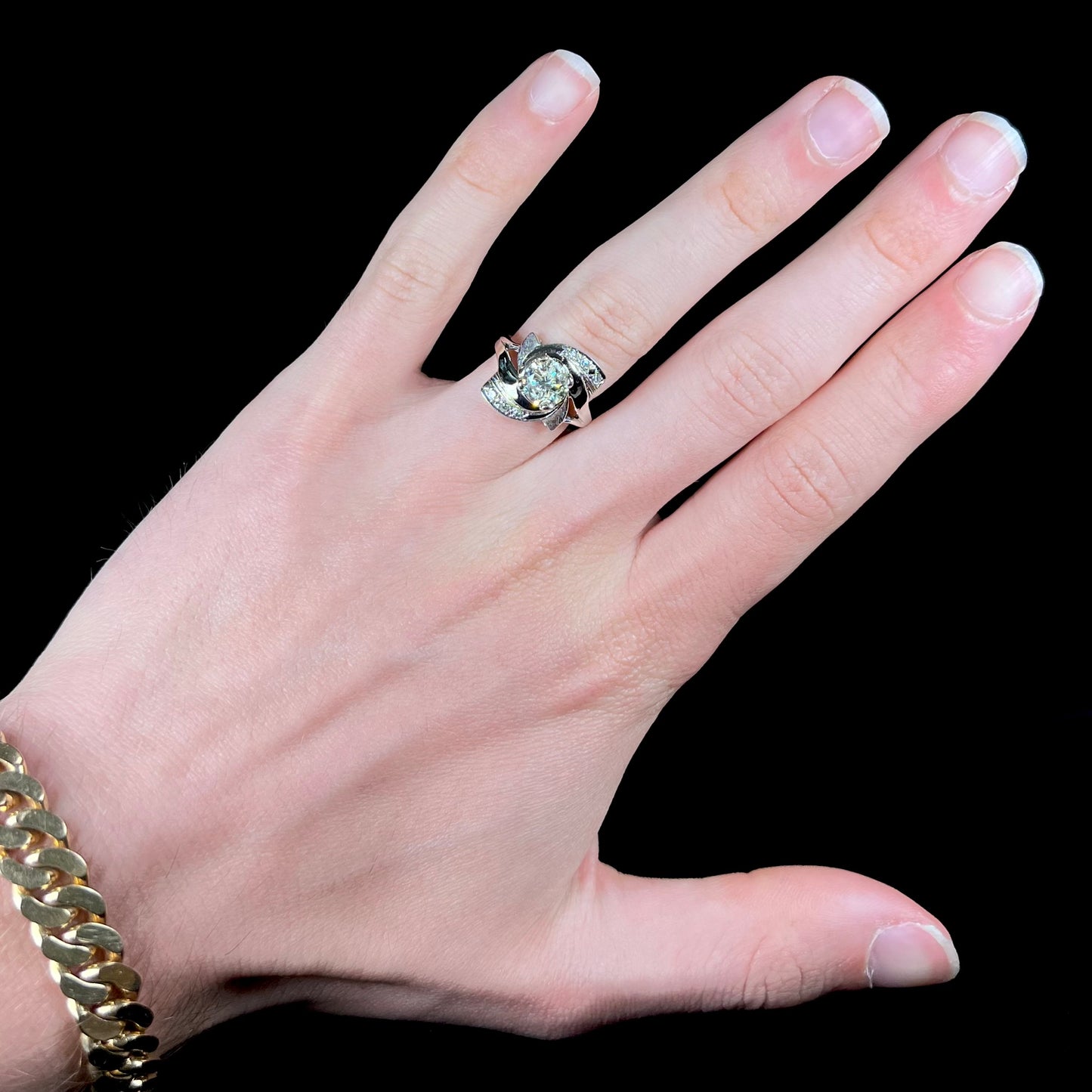 A vintage, Art Nouveau style diamond engagment ring. The ring is white gold with a yellowish, M colored, 1.24 carat diamond.