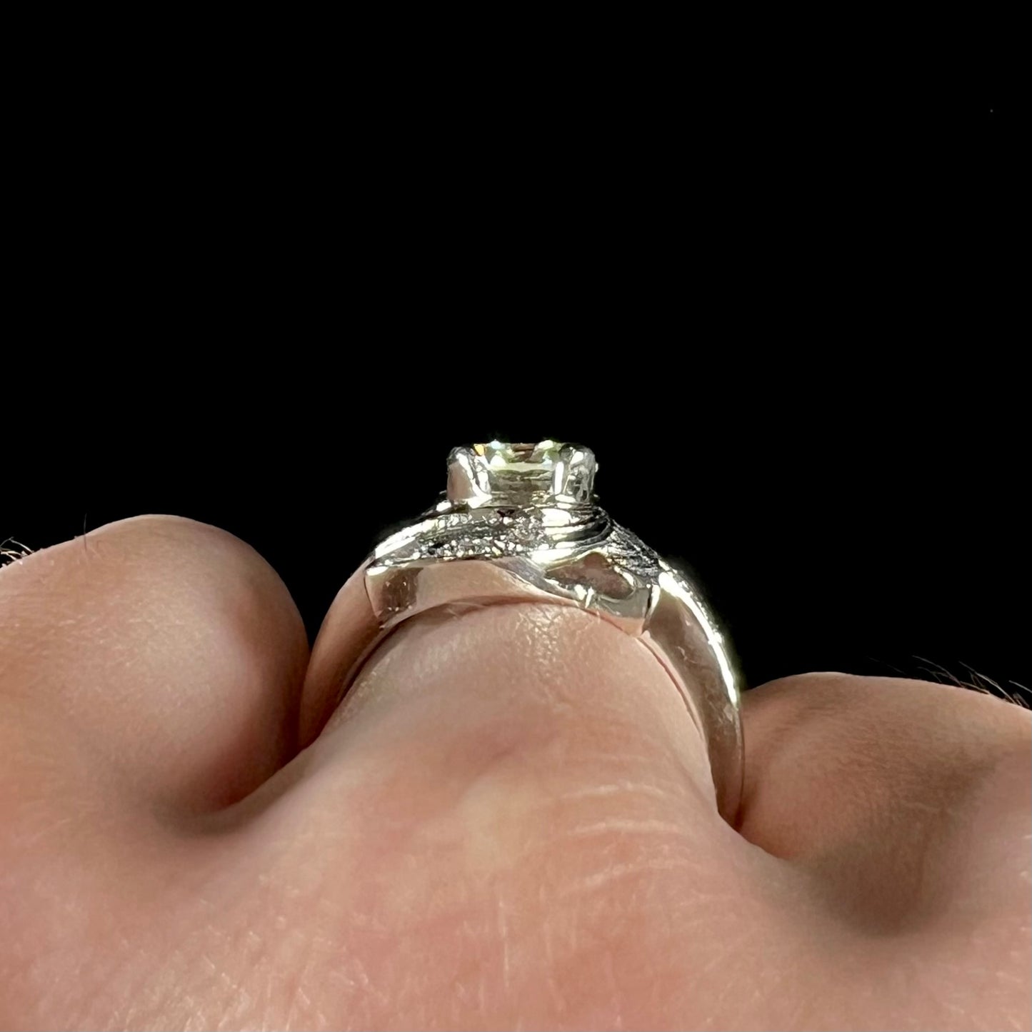 A vintage, Art Nouveau style diamond engagment ring. The ring is white gold with a yellowish, M colored, 1.24 carat diamond.