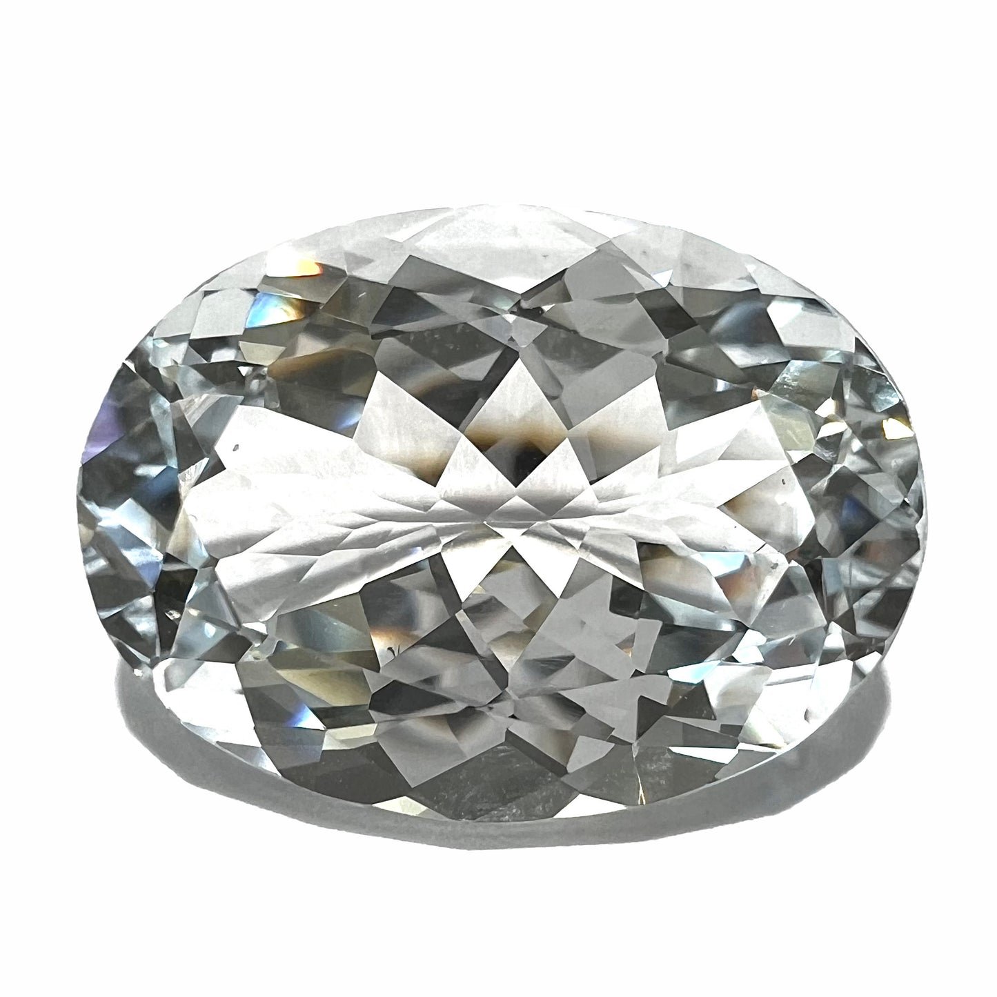 A loose, faceted oval cut white topaz gemstone. The stone is large in size.