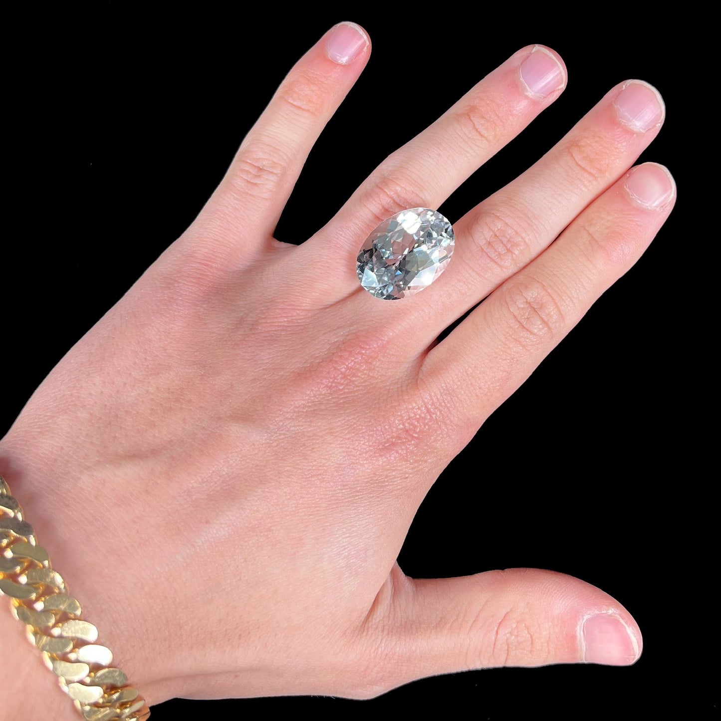 A loose, faceted oval cut white topaz gemstone. The stone is large in size.