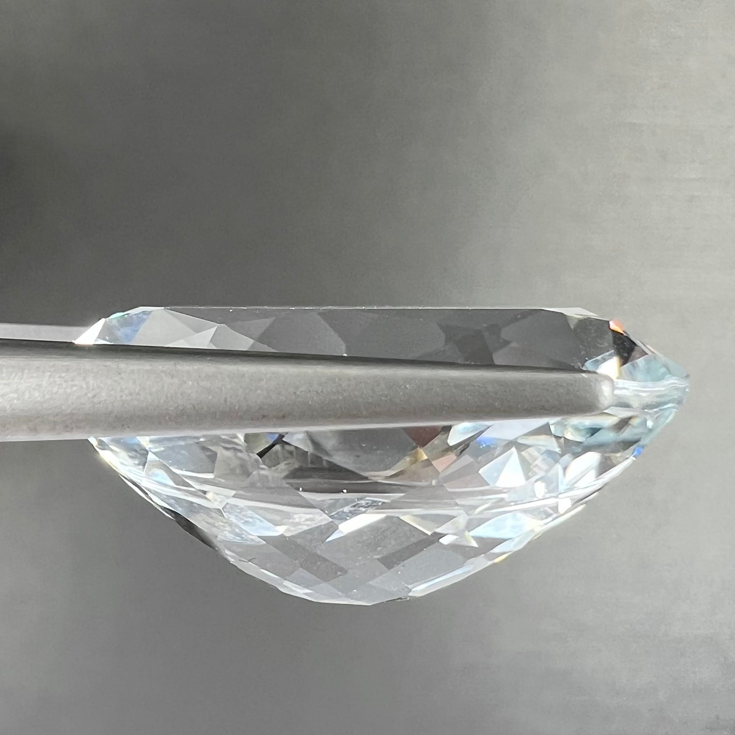 A loose, faceted oval cut white topaz gemstone. The stone is large in size.
