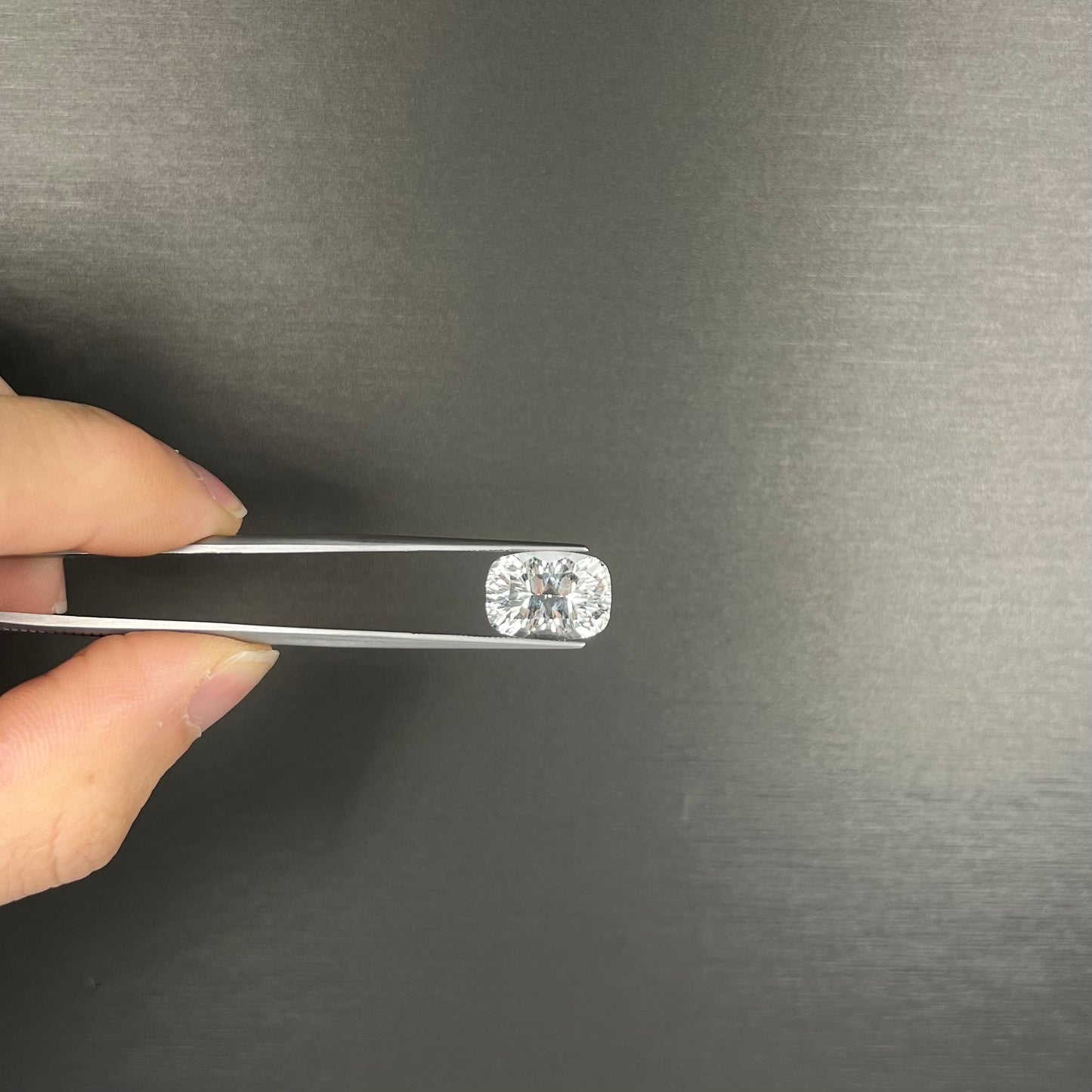 A loose, modified laser cushion cut white topaz gemstone.