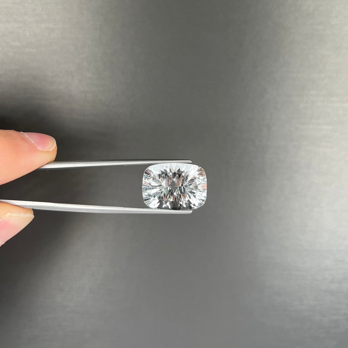A loose, cushion laser cut white topaz stone.