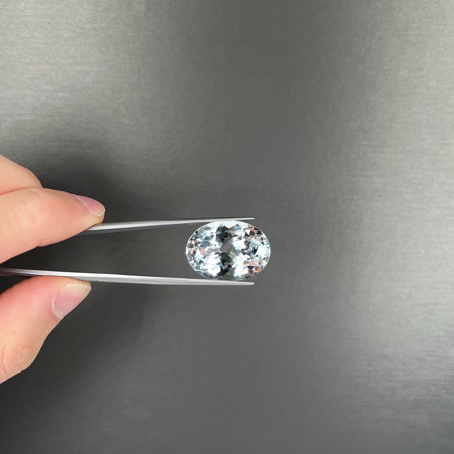 A loose, faceted oval cut white topaz gemstone. The stone is large in size.