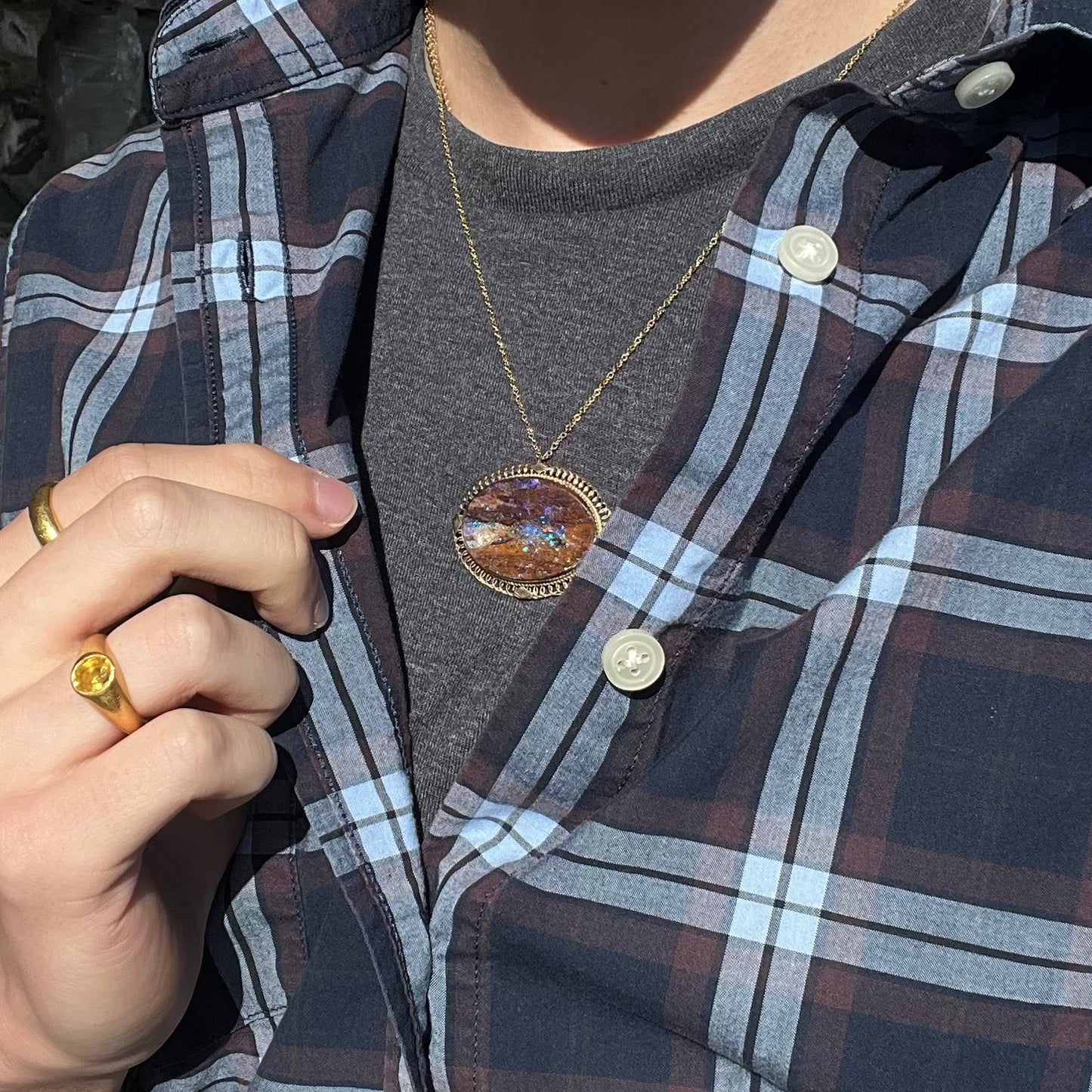 A yellow gold filigree style brooch/pendant combination piece set with a purple opalized wood stone from Duck Creek, Australia.