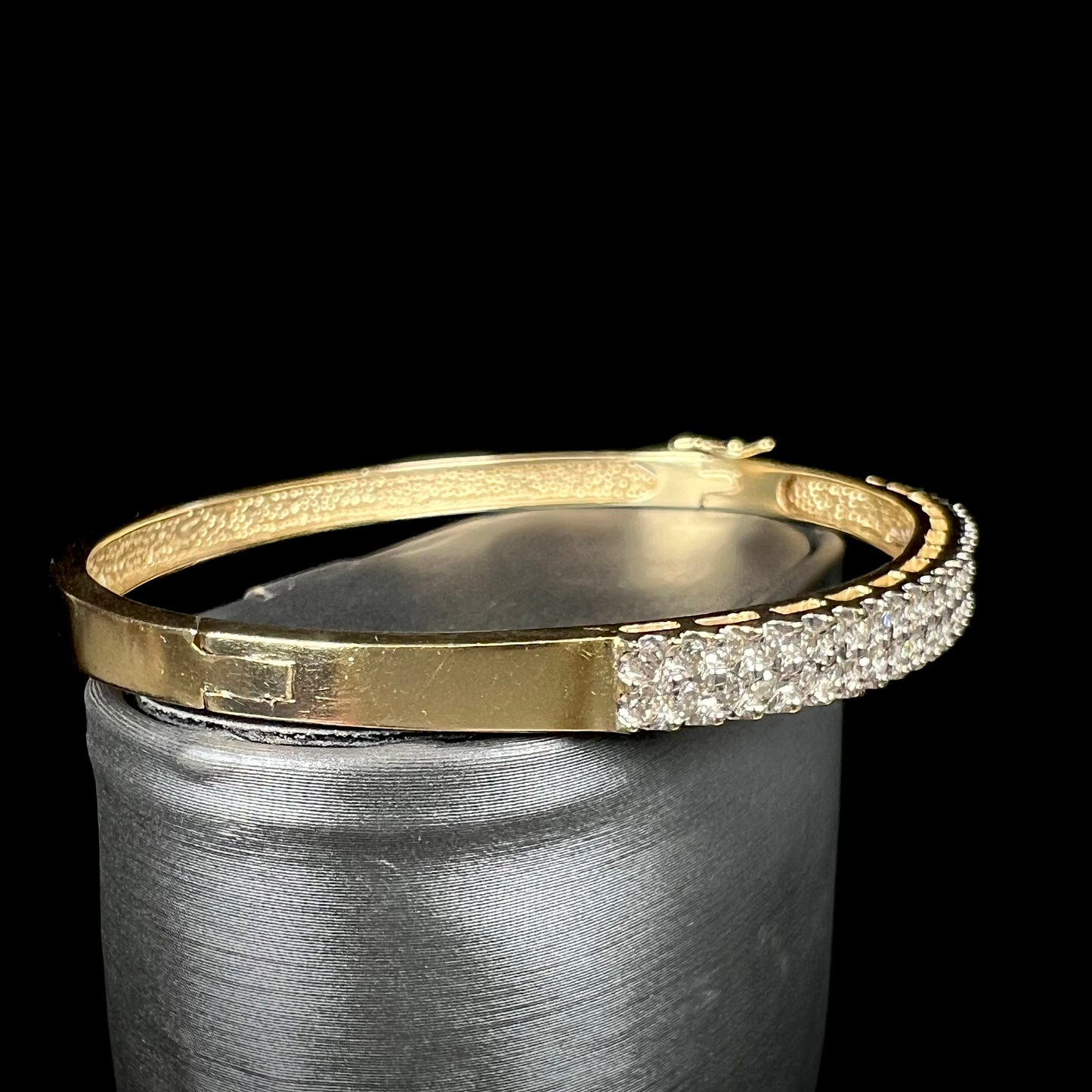 A ladies' hinged yellow gold bangle bracelet set with 50 Standard Round Brilliant Cut diamonds.