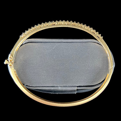 A ladies' hinged yellow gold bangle bracelet set with 50 Standard Round Brilliant Cut diamonds.
