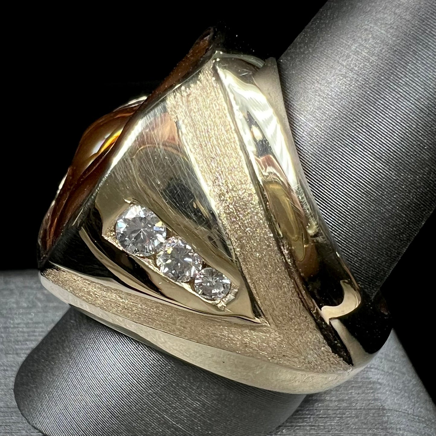 A men's heavy yellow gold ring set with a Mexican fire agate stone and three round brilliant cut diamond accents.