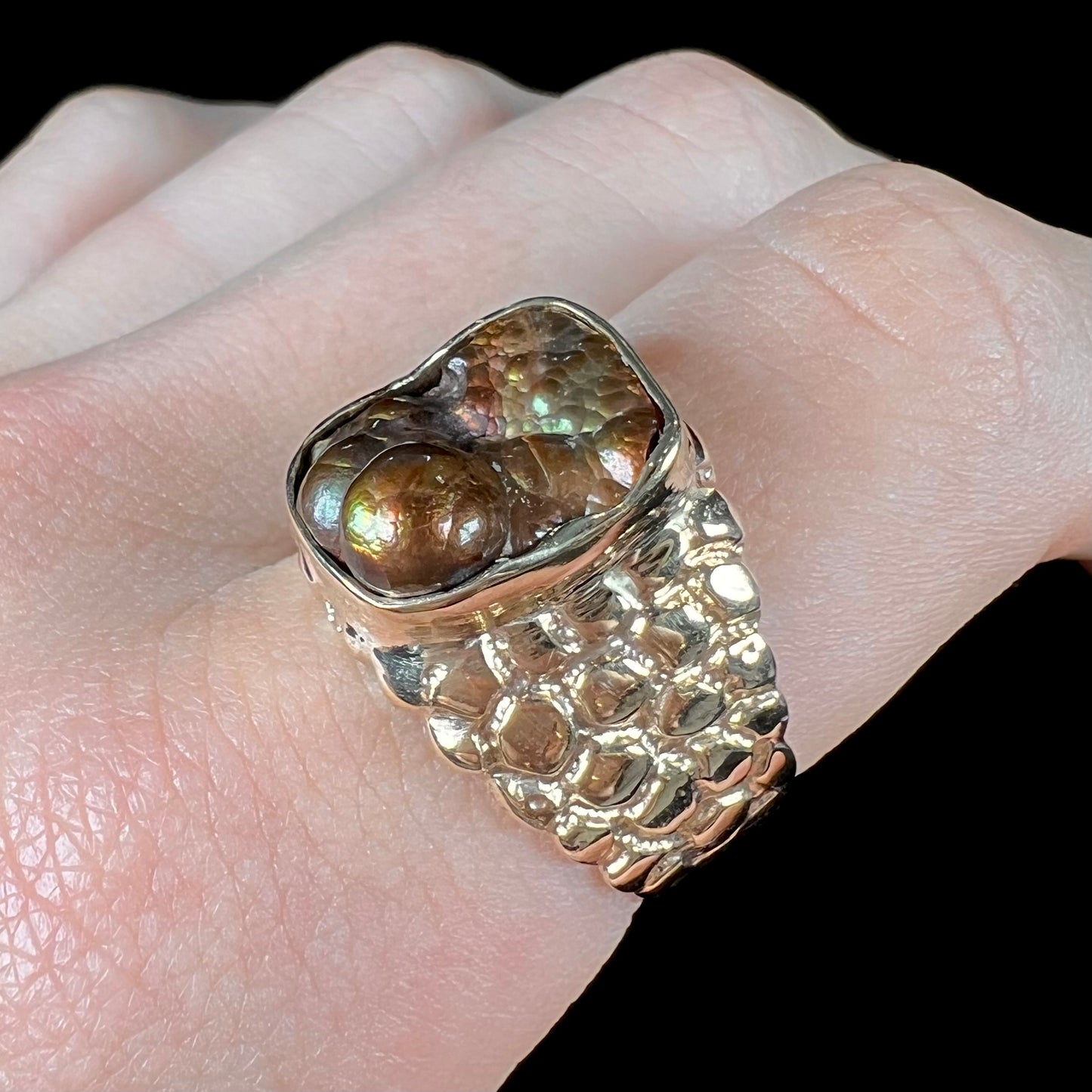 A men's yellow gold, nugget style ring set with a bubbly, California fire agate stone.