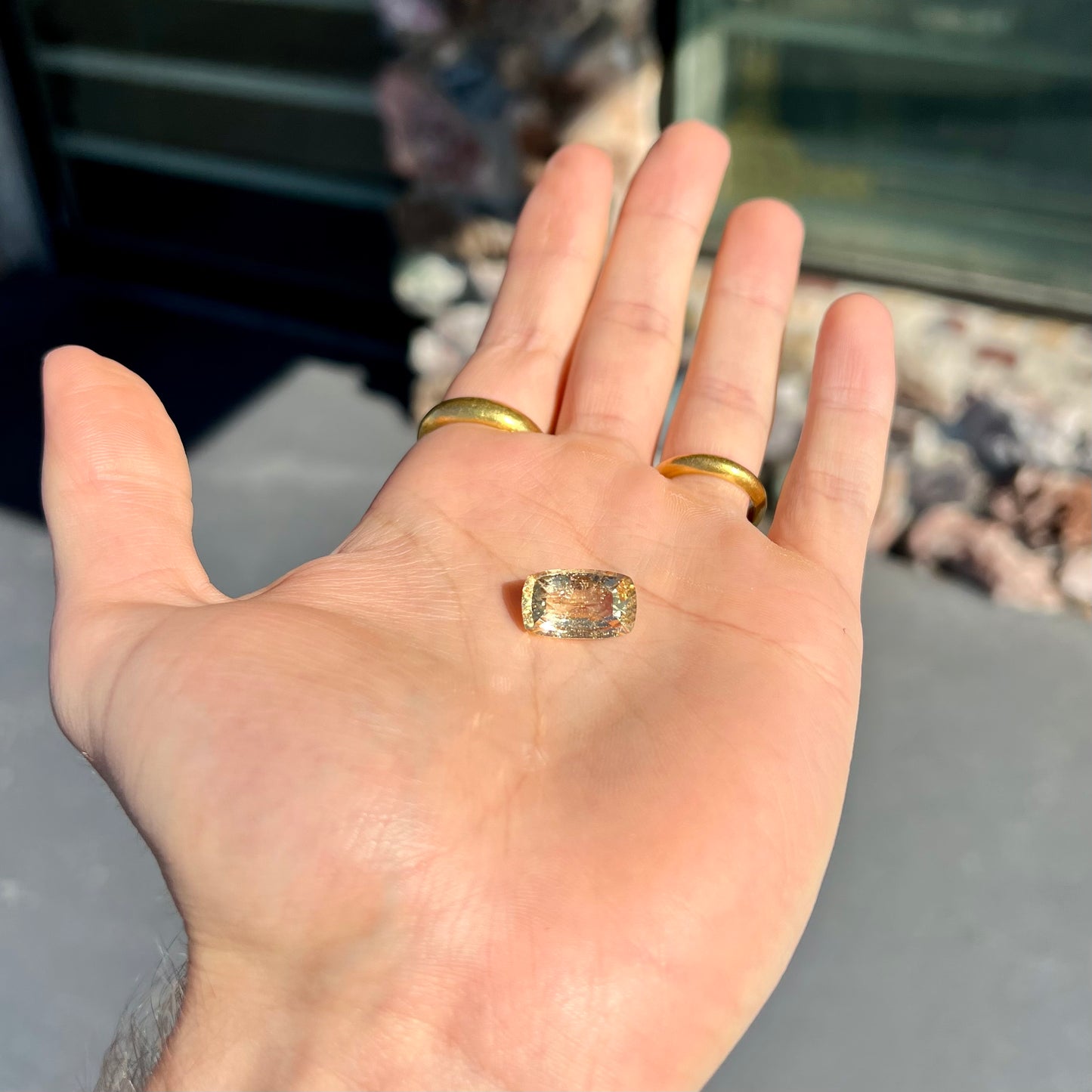 A loose, checkerboard cushion cut golden topaz gemstone. The stone is a yellow color.