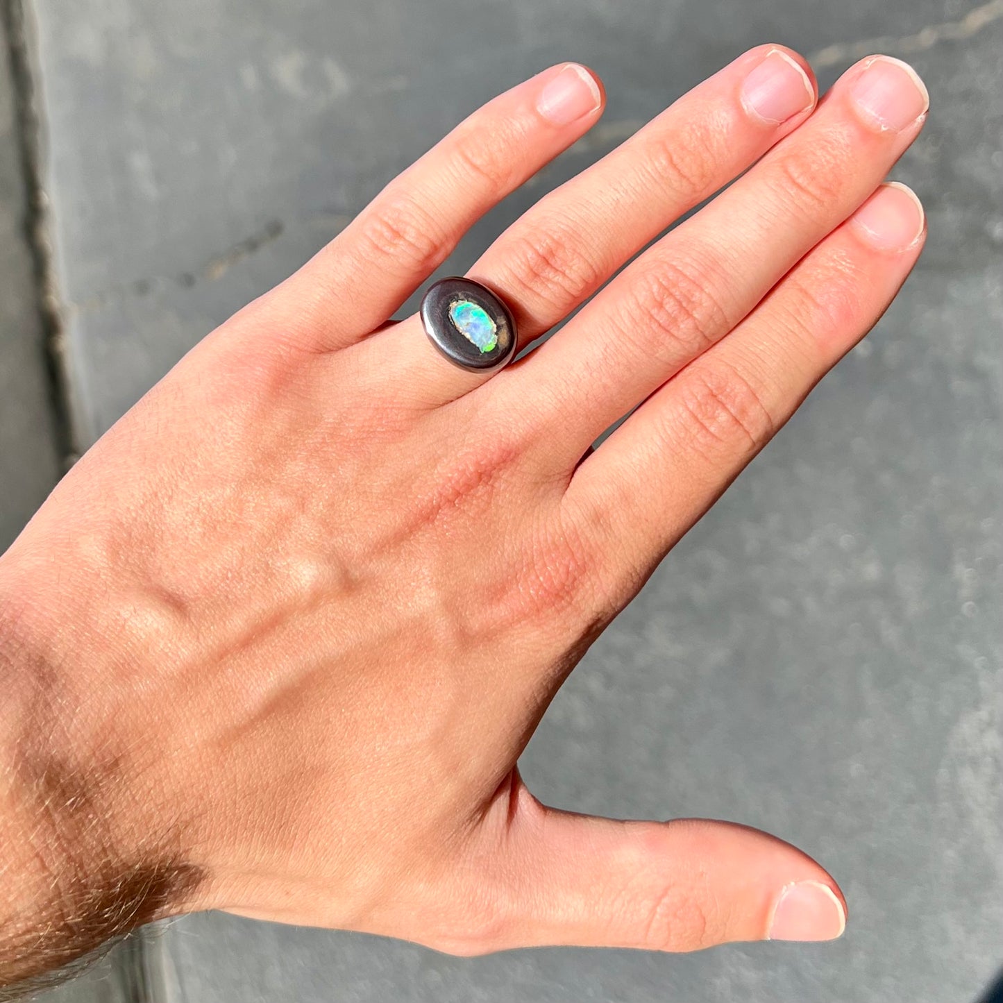 A polished Yowah nut opal stone. The opal shines blue and green colors.