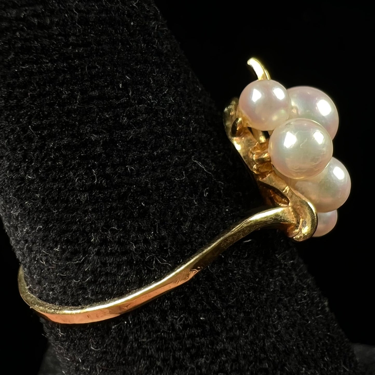 A yellow gold Akoya pearl cluster ring. The pearls are round with pink overtones and resemble bubbles.